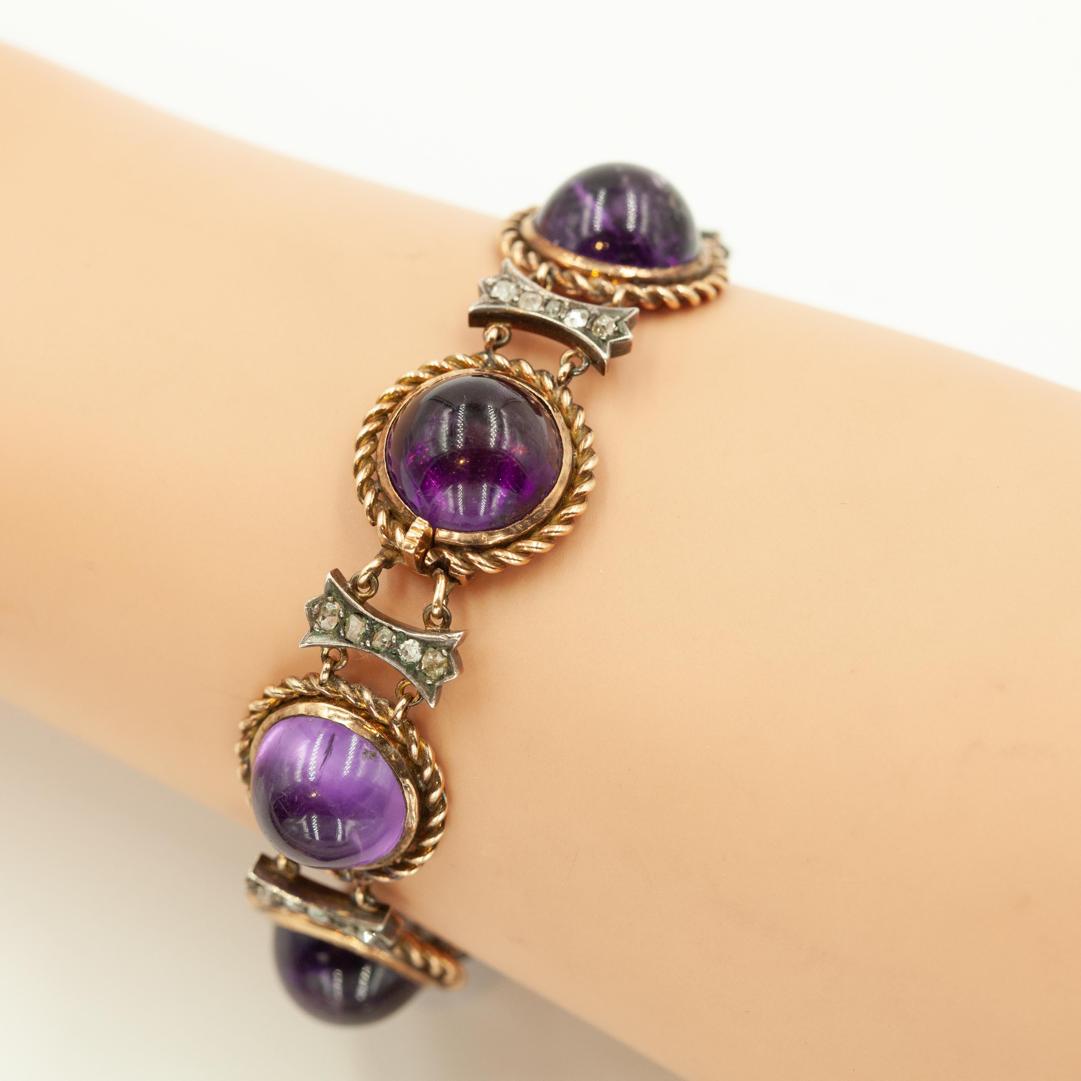 Un exquis bracelet ancien serti d'une série d'améthystes cabochon richement colorées. Les améthystes rondes sont encadrées par des bordures en corde d'or torsadée, alternant avec des maillons ajourés rehaussés de diamants, sertis d'argent et d'or 14
