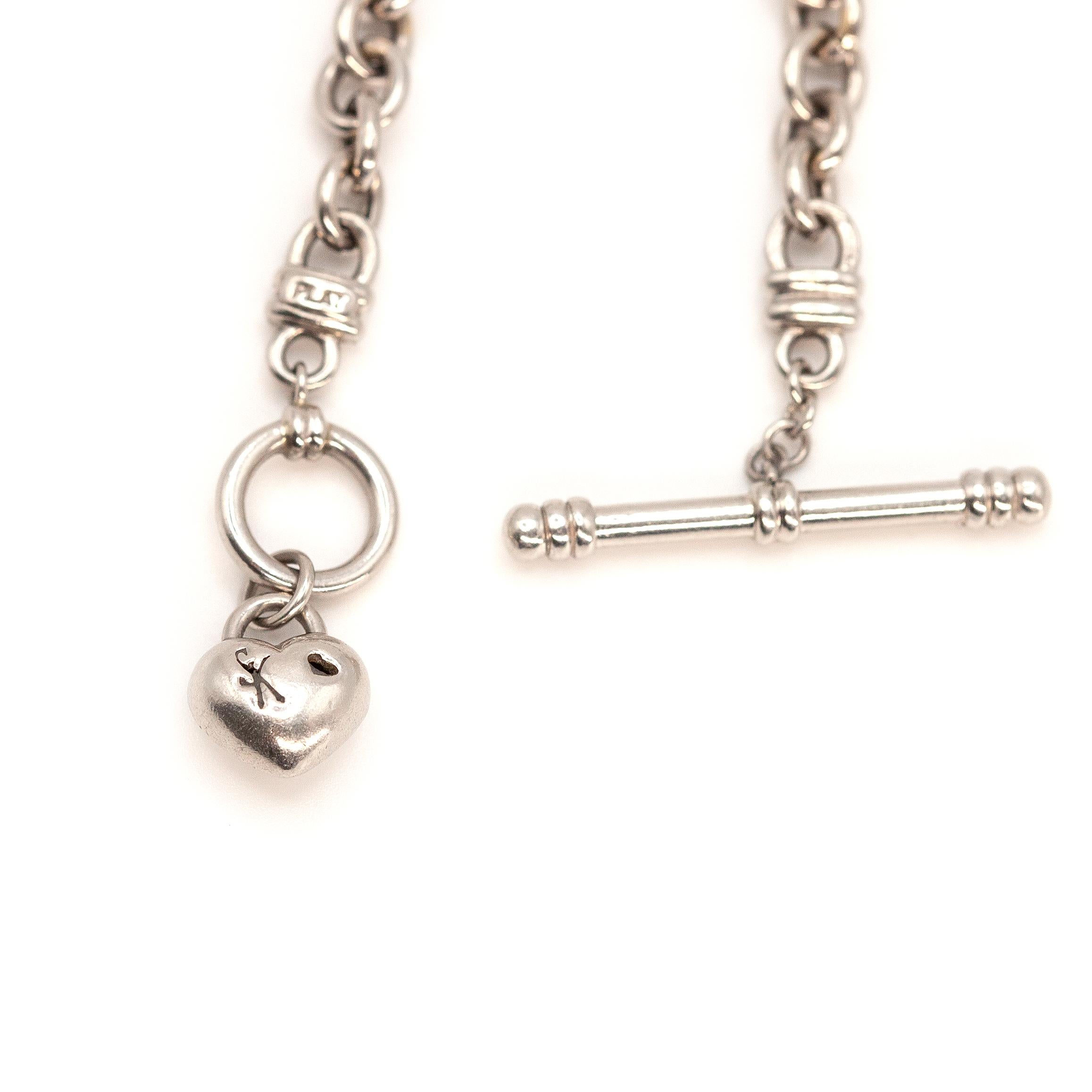 Questo intramontabile ed elegante bracciale con alamari di diamanti, squisitamente realizzato in platino, presenta un romantico ciondolo a forma di cuore e una goccia di diamante su due lati con 18 diamanti taglio brillante di colore G e purezza