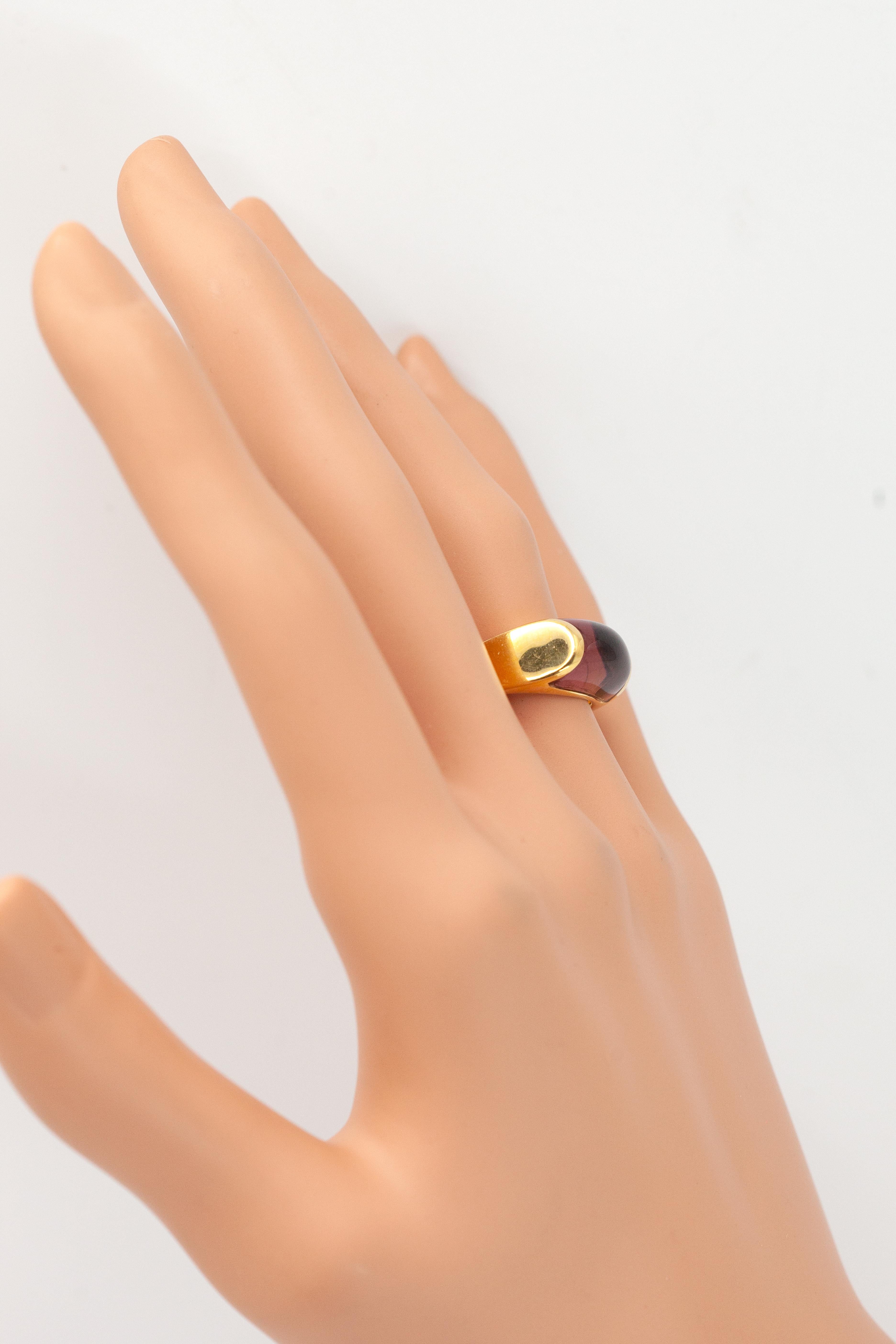 Cette bague signée Bvlgari est ornée d'une rubellite cabochon sertie dans une monture en or jaune 18 carats réalisée par des experts. La pierre précieuse lisse présente de riches teintes rose framboise avec des inclusions naturelles, ce qui ajoute