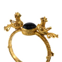 Bracciale rigido in oro giallo 18 carati con uccellino intagliato e zaffiro nero a forma di stella