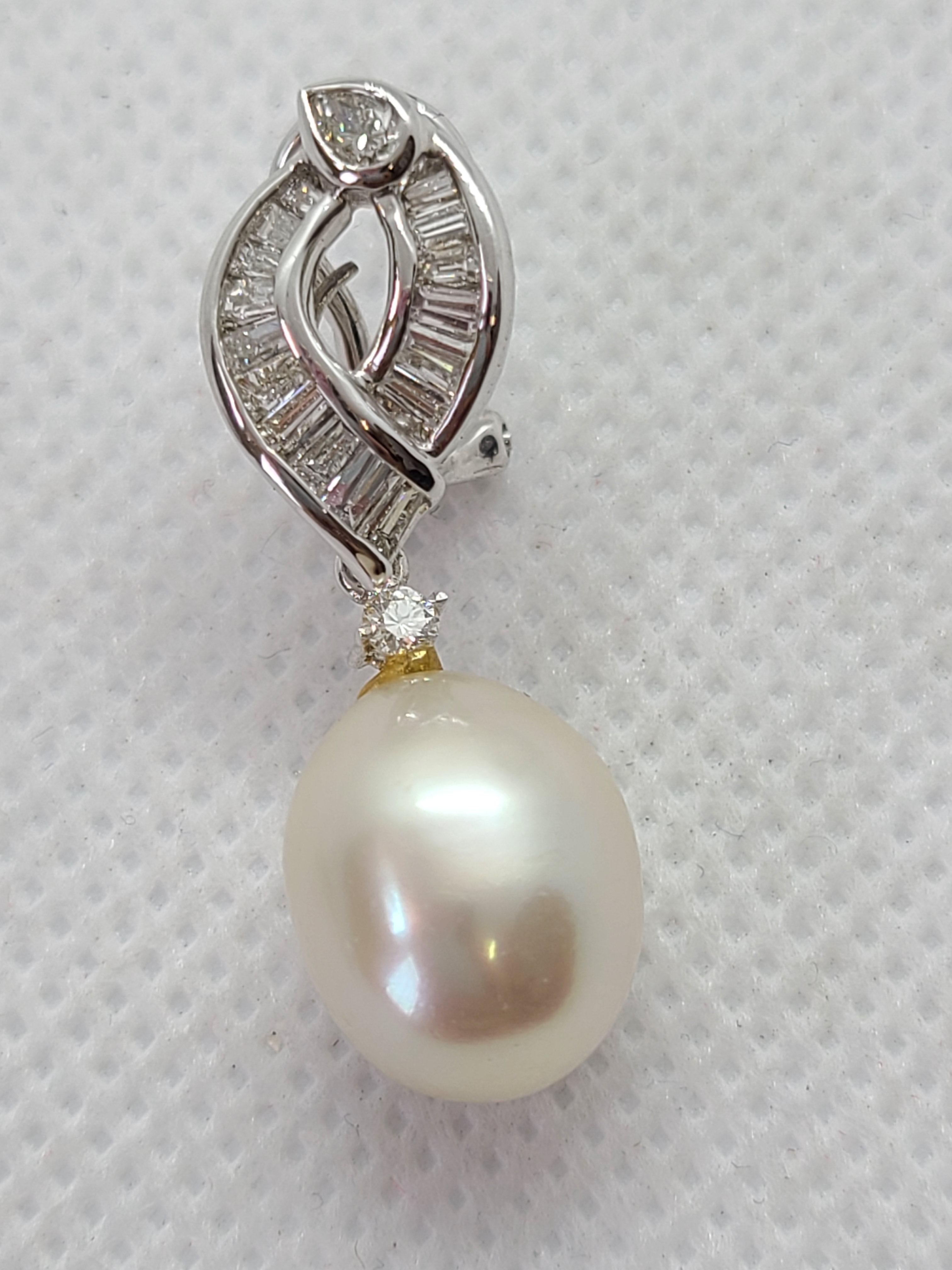 Paire d'Eleg en perles de culture des mers du Sud, chacune présentant des perles d'environ 10 mm, élégamment rehaussées de diamants naturels et serties dans de l'or 18 carats. Chaque boucle d'oreille mesure environ 3,1 cm de long. 