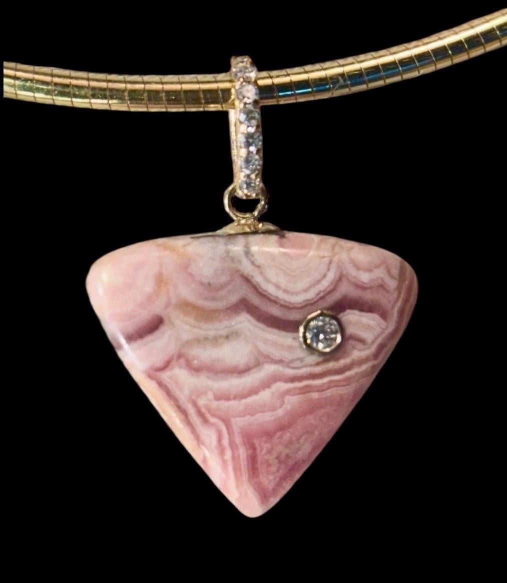 Rhodochrosite Trillion Pendant with Diamonds

Rhodochrosite, Diamonds & 14k Gold

Carved rhodochrosite trillion (20mm diameter) with a  center gold bezeled 2mm diamond and diamond bail.

Rhodochrosite is known as the “Stone of the Compassionate