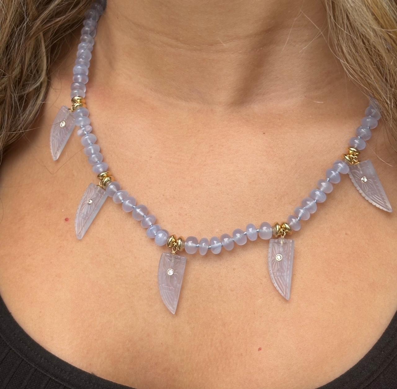 Chalcedony & Diamond Necklace

Chalcedony, Diamonds and 14k Gold

One-of-a-kind Necklace of 6.5mm chalcedony beads with five hand carved chalcedony drop pendants (shark tooth shaped) with beautifully carved floral motifs. 

Each drop pendant has a