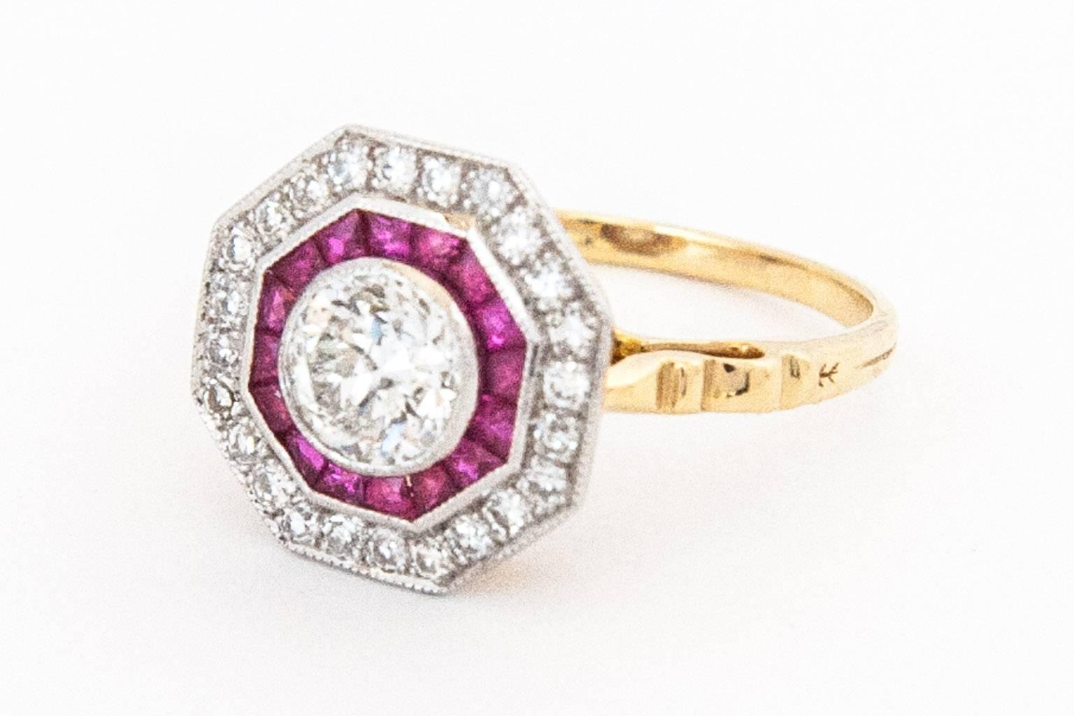 A diamond and ruby square octagonal target cluster ring, with a central semi-modern cut diamond bezel set in 18 karat white gold within a two row border of 16 tapered square cut rubies and 24 single cut diamonds with an 18 karat yellow gold carved