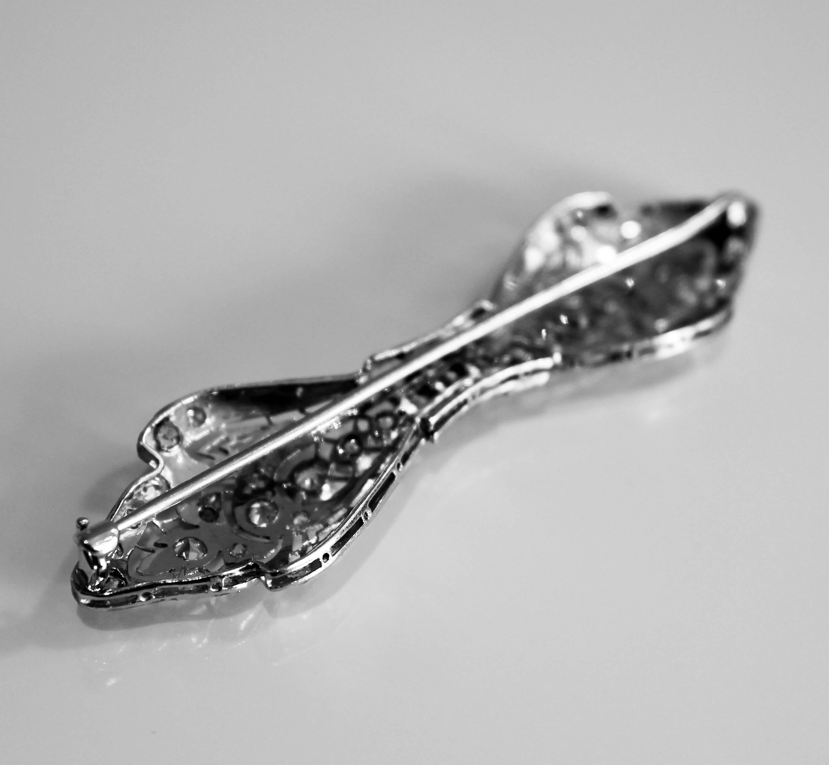 Diamond Art Deco brooch with forty nine old European cut diamonds grain set in platinum in a bow type shape with roller catch and pin fittings. Handmade. Circa 1930.