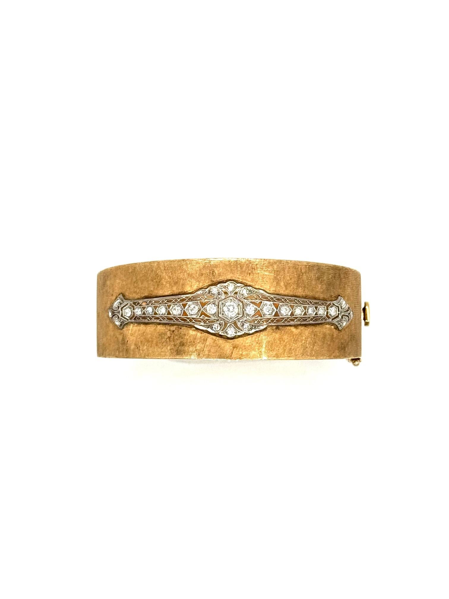 A bold and elegant wide bangle bracelet crafted in brushed 14K yellow gold and accented with a platinum plaque set with 13 old mine and European cut diamonds, including 10 round and 4 small accent stones, totaling approximately 0.85 carats. The