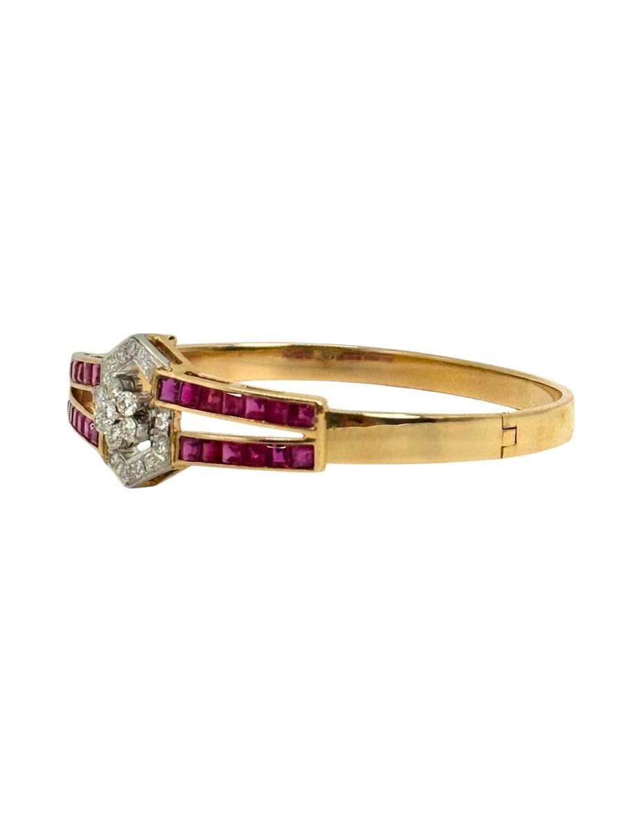 Elegant vintage bangle bracelet crafted in 14K yellow gold, featuring a striking design of channel-set square-cut rubies totaling approximately 3.00 carats. At the center is a brilliant cluster of diamonds weighing approximately 0.65 carats, set in
