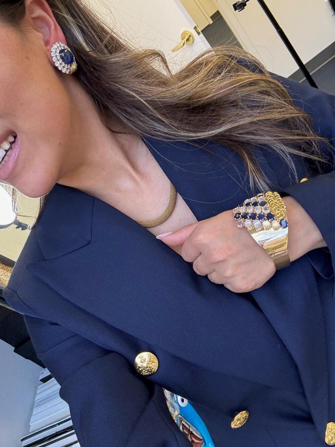 Un bracelet manchette audacieux et luxueux en or jaune 14 carats présentant une grappe spectaculaire de 13 saphirs de taille ovale d'un bleu profond totalisant environ 20,16 carats, associés à 14 pierres de lune ovales lumineuses totalisant environ