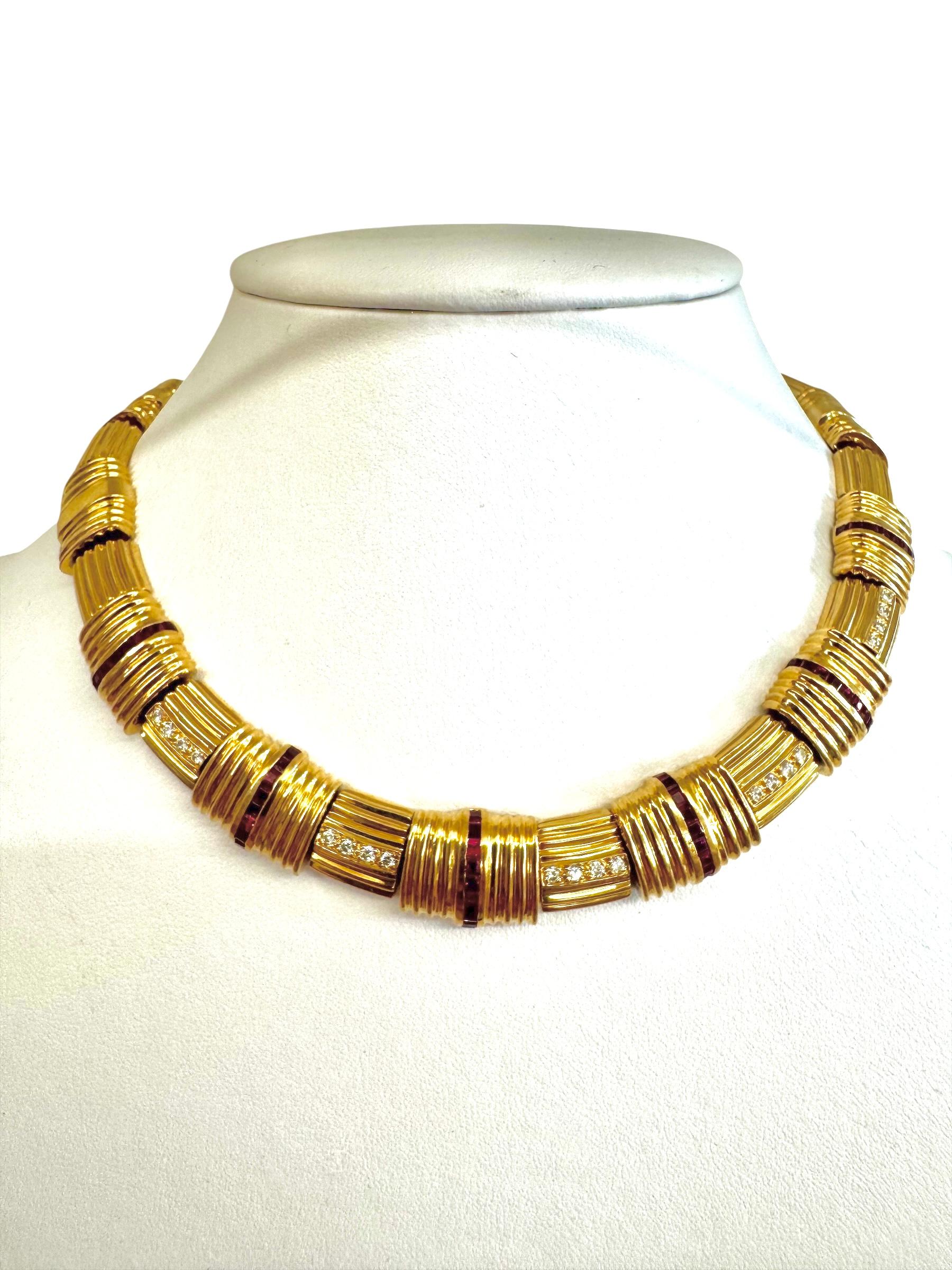 Un collier audacieux et élégant en or jaune 18K composé de segments nervurés texturés, alternant avec des sections serties de diamants ronds en serti-canal et de rubis taillés en baguette. Le collier présente un design élégant et structuré avec une