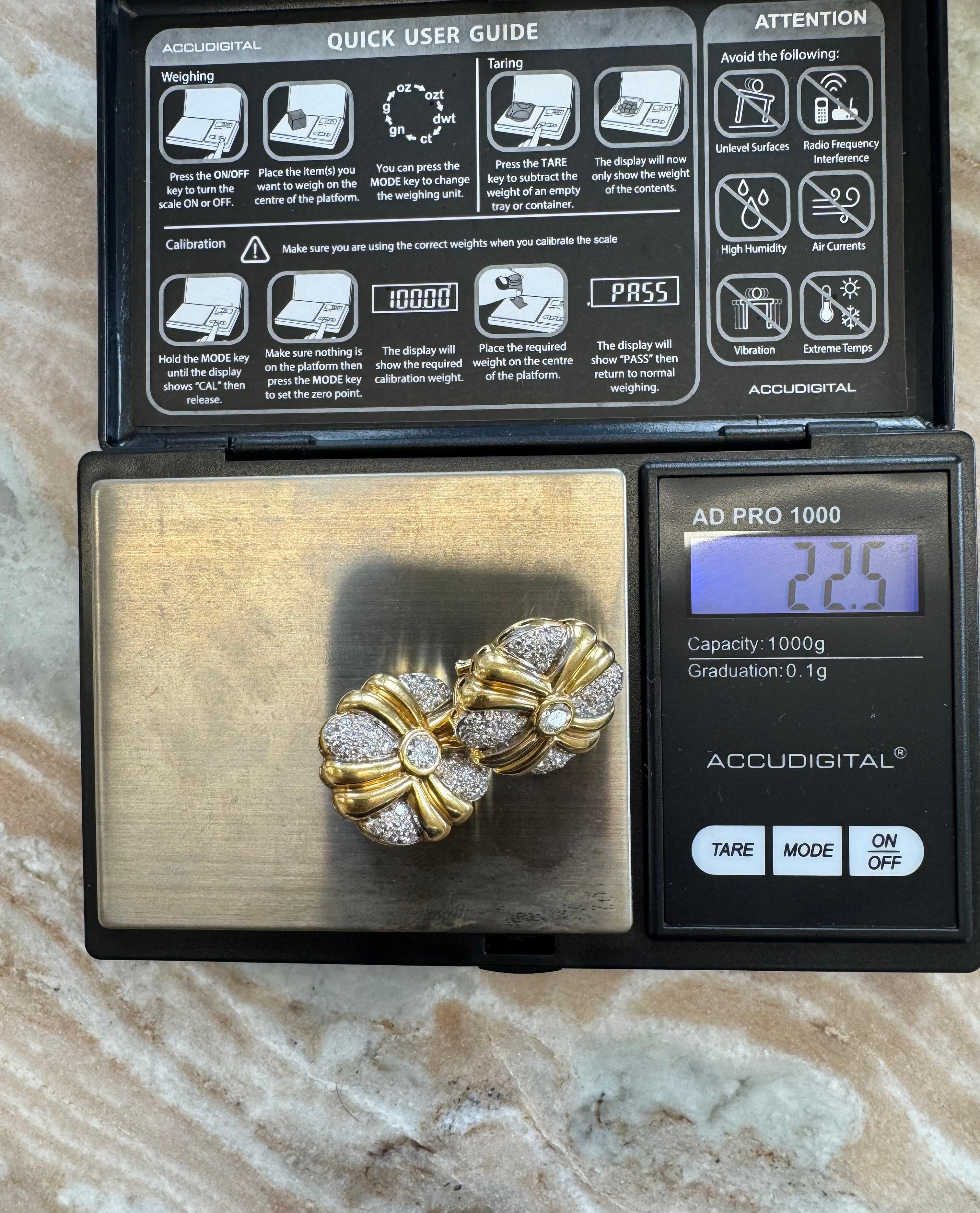Une paire audacieuse et sculpturale de boucles d'oreilles clips vintage en or jaune 18 carats, conçues dans un motif floral arrondi avec des segments d'or nervurés rayonnant à partir d'un diamant rond central serti sur un chaton. Chaque pétale est