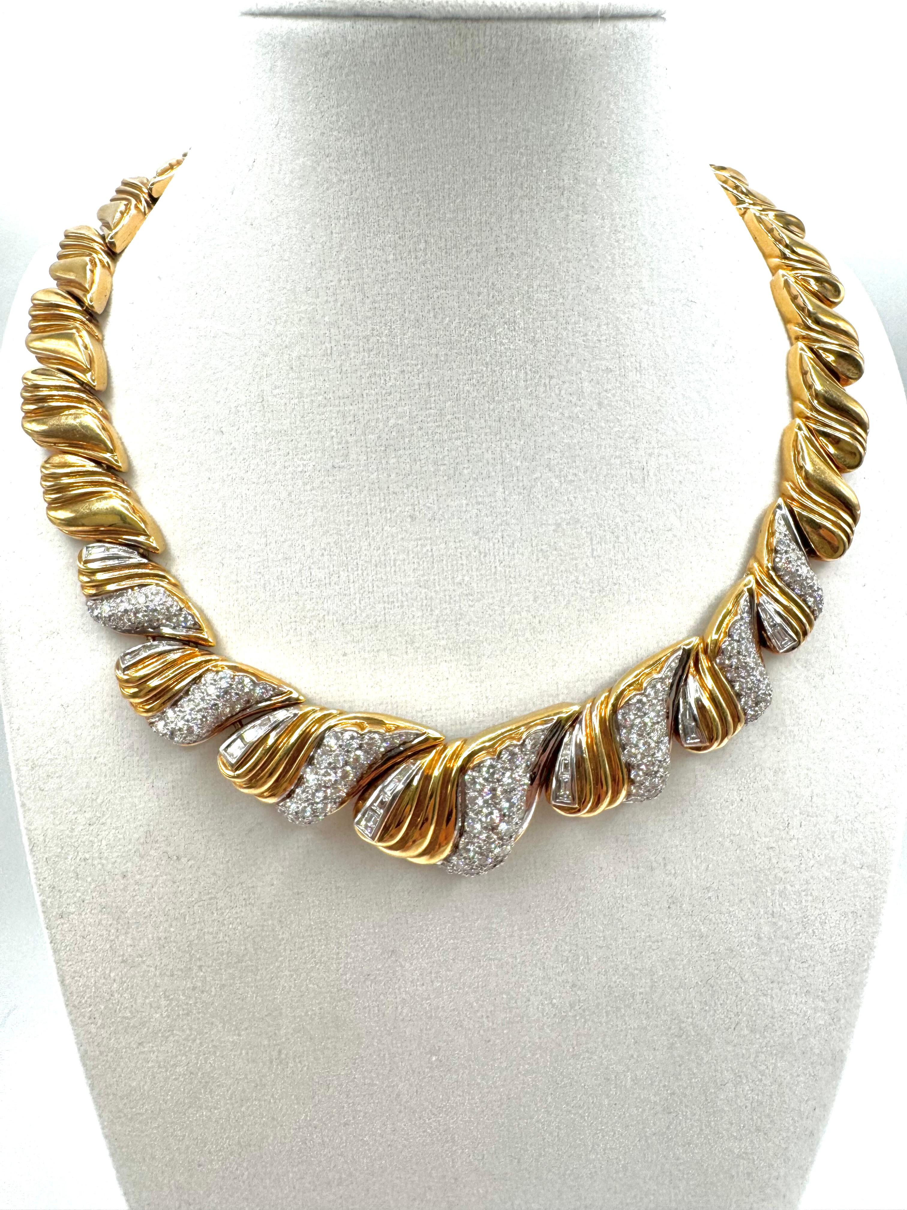 Questo collier scultoreo, realizzato in oro giallo 18 carati, presenta un dinamico motivo a onda ornato da un'abbagliante combinazione di diamanti. Il design alterna creste d'oro lucidissime e gruppi di diamanti tondi brillanti incastonati a pavé