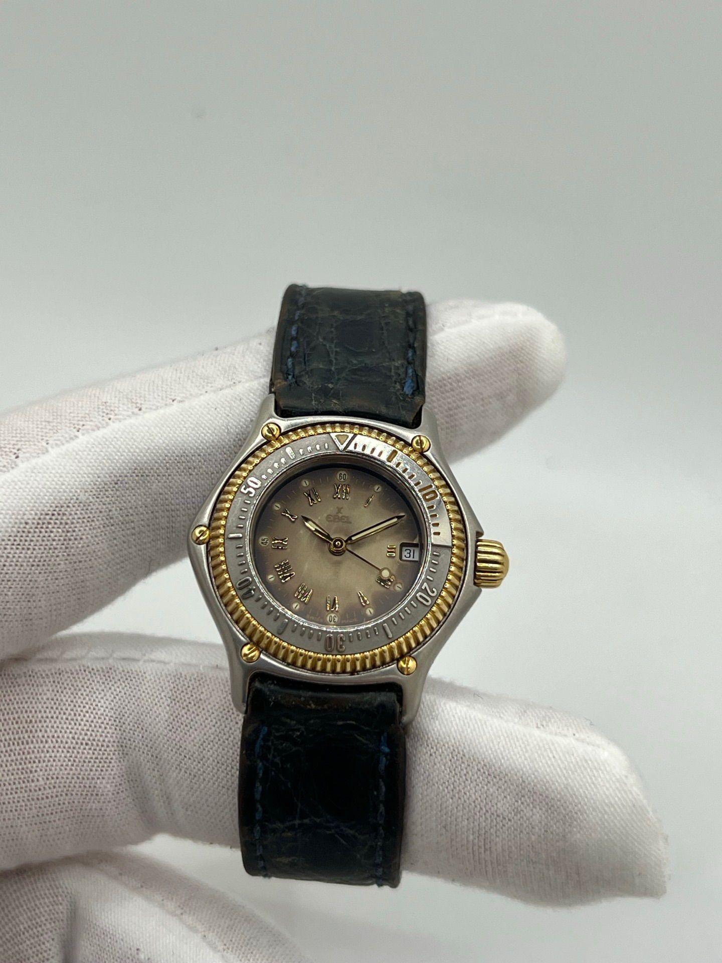 Entdecken Sie die elegante Ebel Discovery 183912, eine wahre Mischung aus Präzision und Stil. Ihr zweifarbiges Gehäuse aus Gelbgold und Edelstahl mit einem Durchmesser von 29 mm strahlt subtilen Luxus aus und ist perfekt mit einem weichen blauen