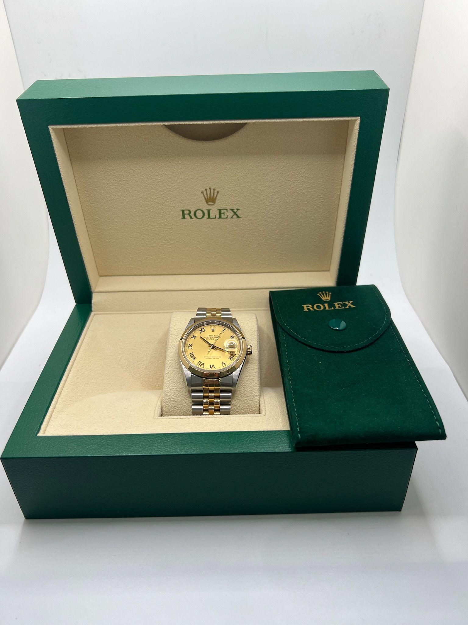 Entdecken Sie diese atemberaubende Rolex Datejust 116203 aus zweifarbigem Gelbgold und Edelstahl, ein zeitloses Symbol für Eleganz und Beständigkeit.

Das strahlend champagnerfarbene Zifferblatt reflektiert das Licht und hebt die goldenen Stabindexe