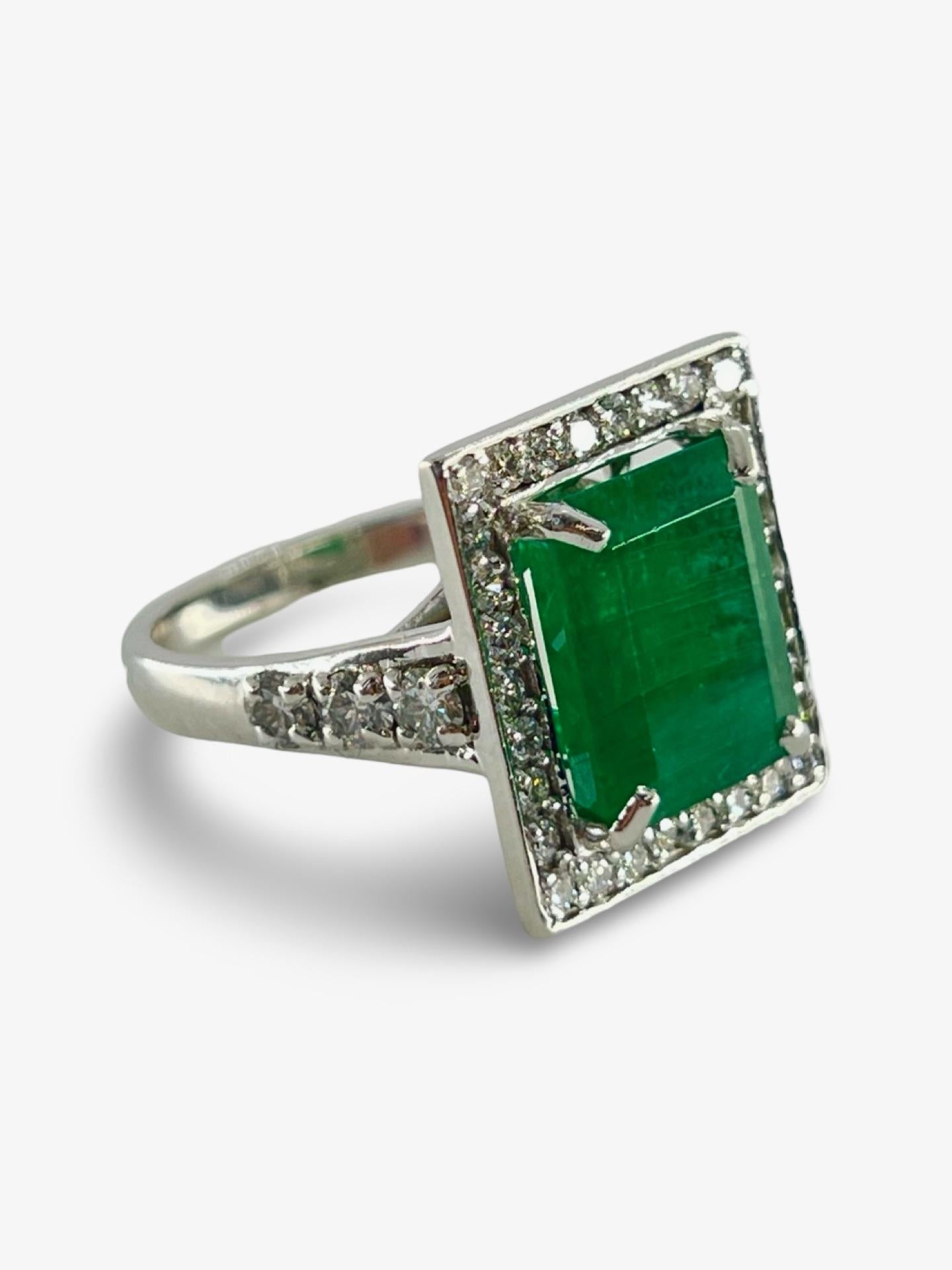 Questo splendido anello è realizzato in lussuoso oro bianco 18 carati (750/1000) e presenta al centro uno splendido smeraldo naturale di circa 6 carati. La vibrante gemma verde è completata da scintillanti diamanti naturali per un totale di 1,5