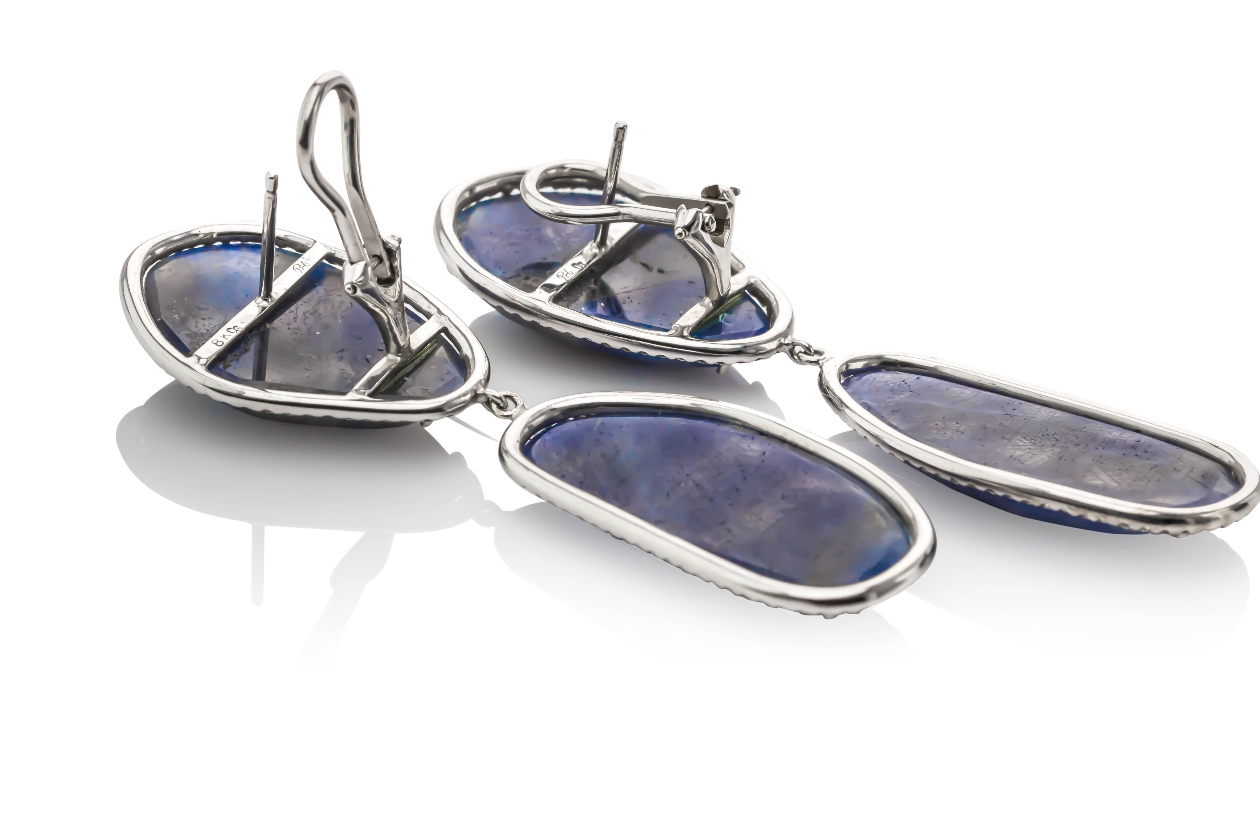 One of a kind 18K white gold blue sapphire and diamond earrings.  Prong set with four sliced blue sapphires weighing 79.78 carats total weight round brilliant cut diamonds weighing 1.15 carats total weight, G color and VS clarity.  Hand-crafted in