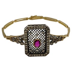 Pulsera de estilo retro en oro amarillo y plata con diamantes y un rubí central