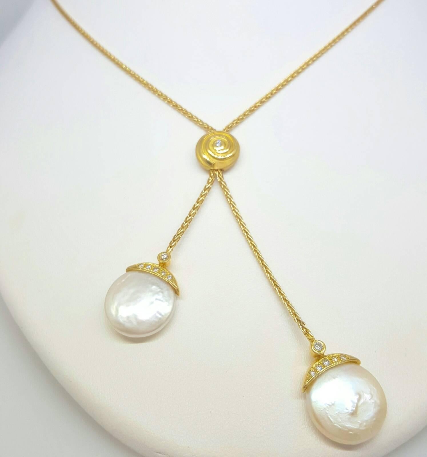 This 18 karat yellow gold Yvel Necklace is set with 13 round brilliant cut diamonds that weigh approximately 0.20 carats total weight and two coin pearls that measure 4.4mm in diameter. The necklace is 18 inches long (20 inches overall including the