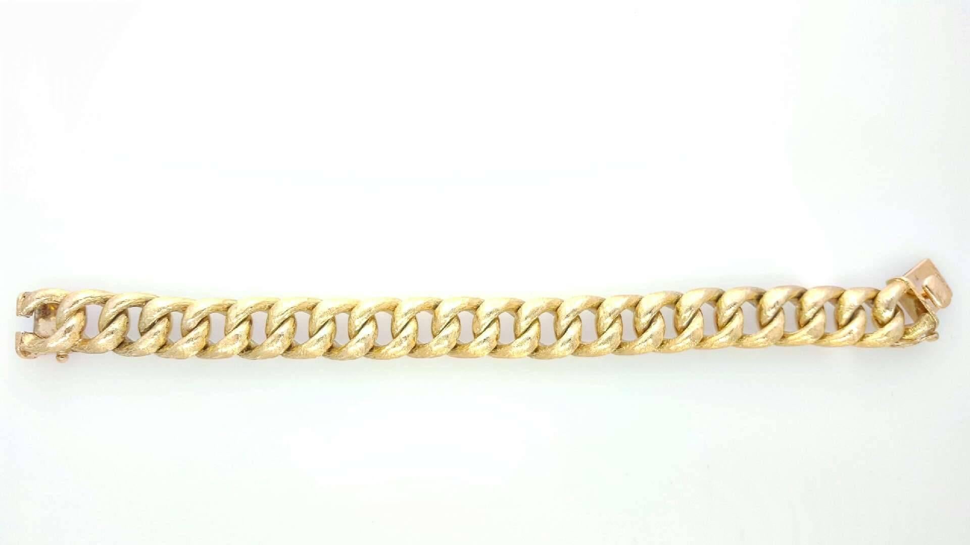 14 Karat Yellow Gold solid Curb Link Bracelet with Push Button release. The top of the bracelet is textured. The bracelet measures 7.5 inches long and weighs 66.5 grams. 