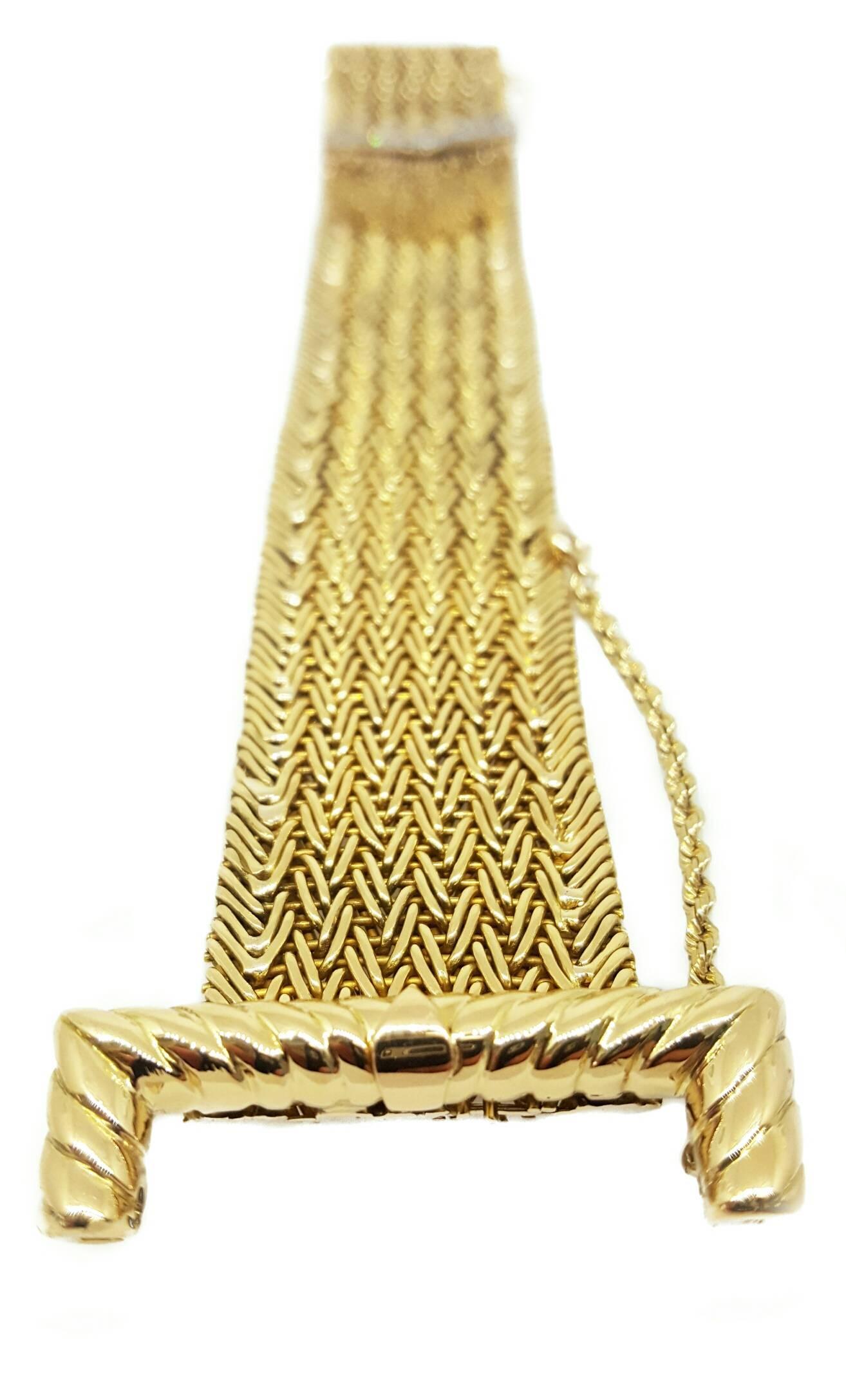 This very unique buckle bracelet was crafted in the 1950s using 18 karat yellow  and white gold. The heavy mesh design and golden tassels give this piece a one-of-a-kind look. The nine round single cut diamonds are set into white gold and have a