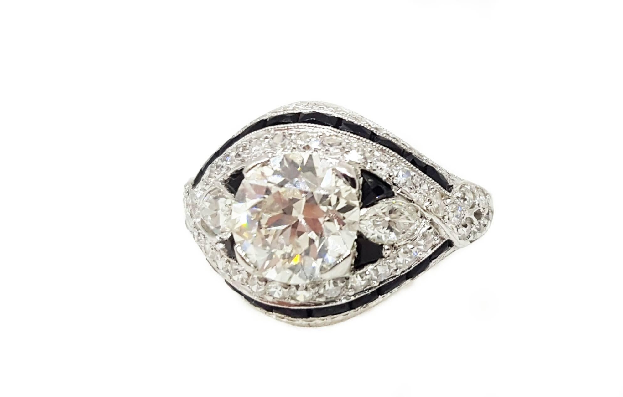 A unique and beautiful ring from the 1930's. Crafted in platinum, the center diamond is a 1.70ct L color, VS2 clarity, Old European cut. In addition to the center diamond, there are 2 Marquise cut diamonds that weigh 0.25ct each and 38 single cut