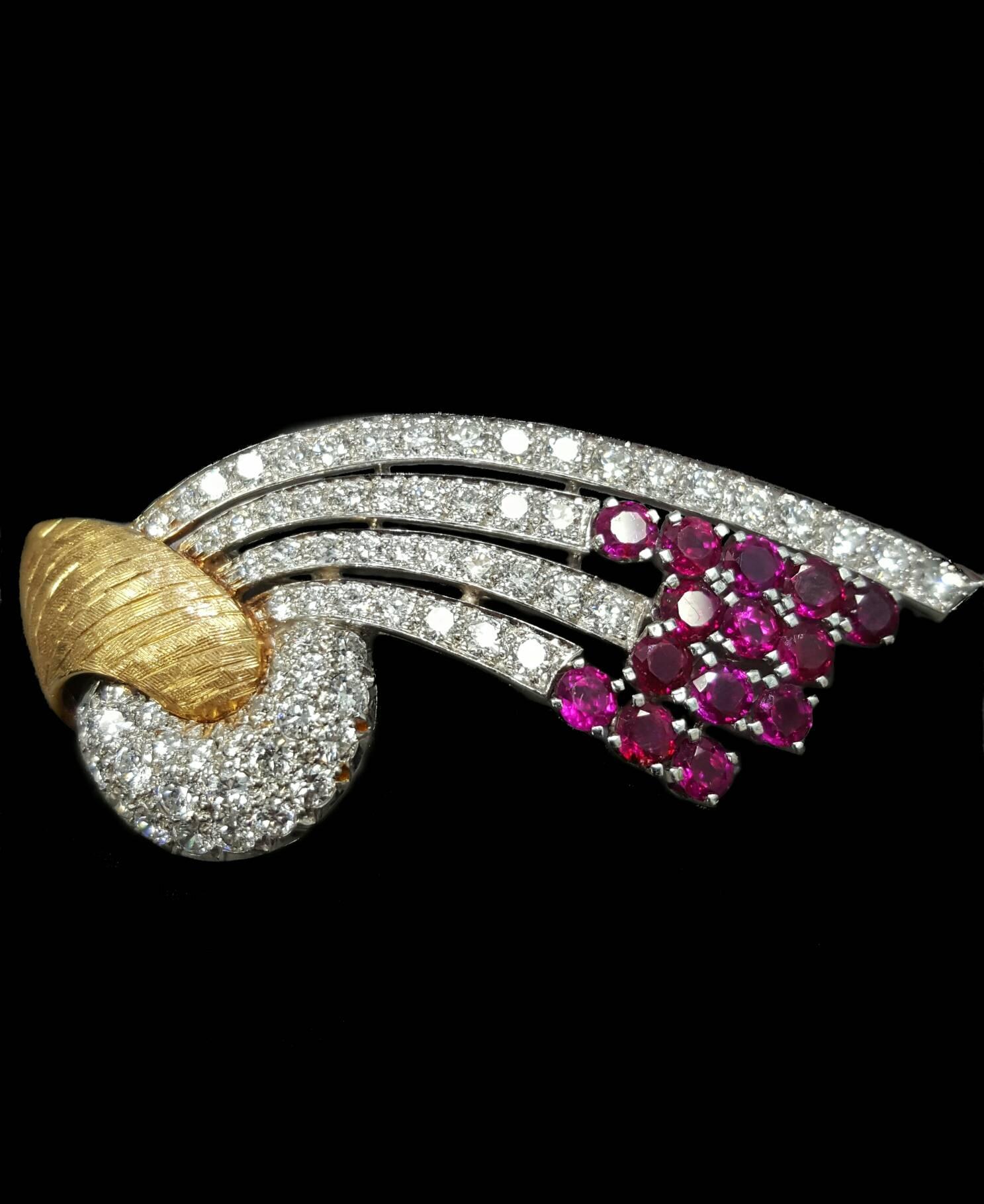 An expertly crafted mid century brooch that is set with 72 Round Brilliant cut diamonds and 14 Round cut rubies. The brooch itself is made from platinum and 18 karat yellow gold. The diamonds are all F to G color and VS1 to VS2 clarity. The rubies