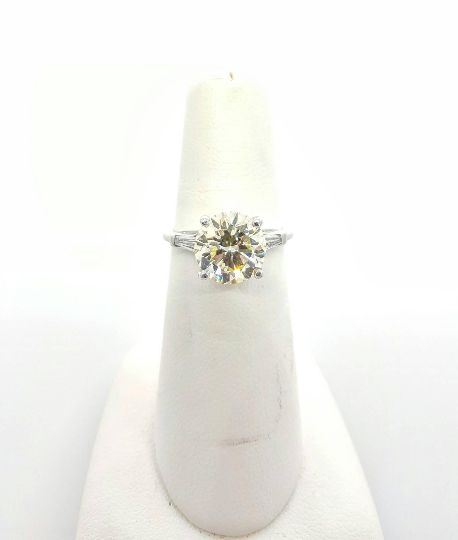 Classic 3 stone ring design featuring a 3.51ct Round Brilliant cut diamond in the center and 2 tapered Baguette cut diamonds on the sides. The center diamond is R-S color and VS2 clarity (No Certificate). 
