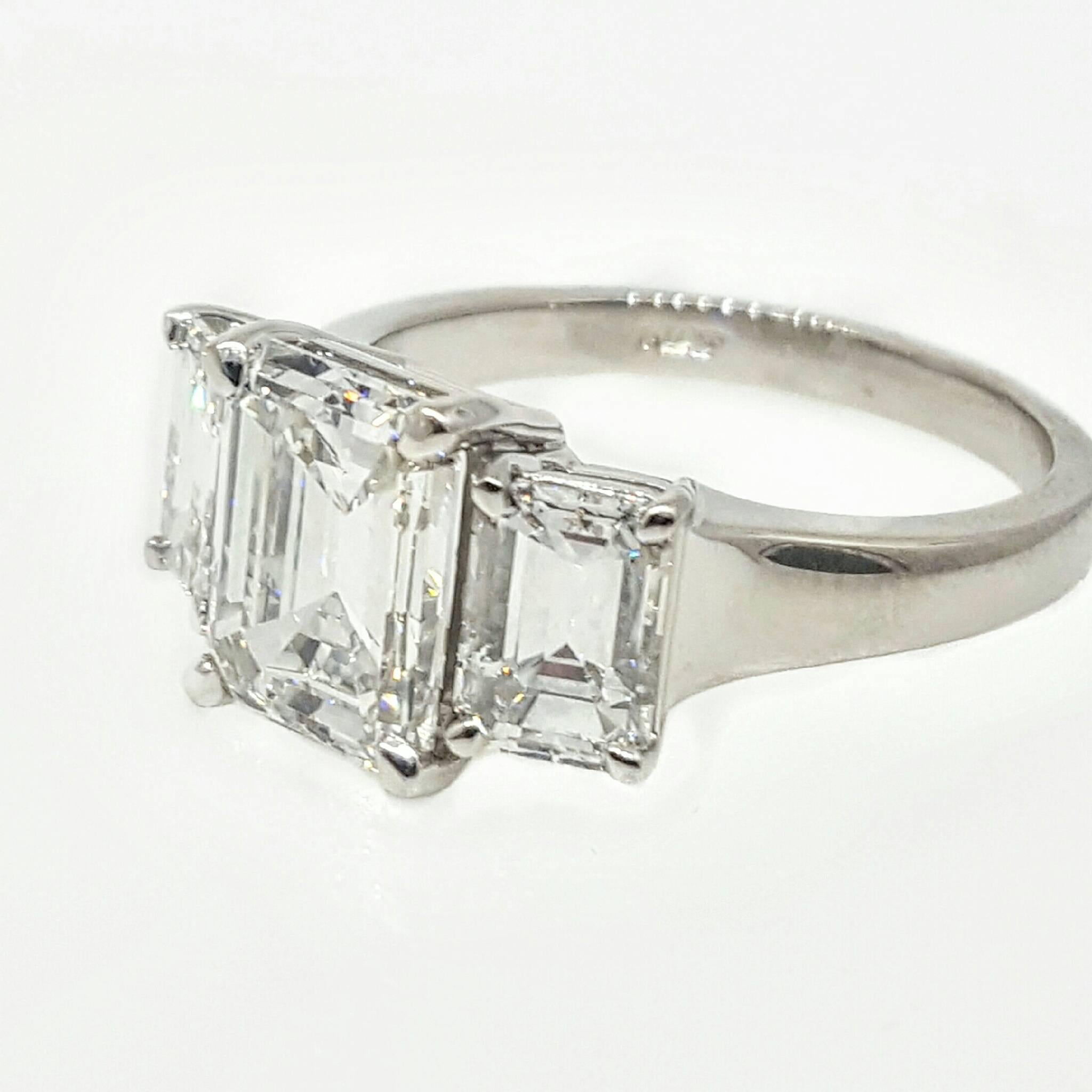 A hand made platinum mounting set with three rectangular emerald cut diamonds. The center diamond weighs 2.84 carats exactly, is G color, VS1 clarity and certified by the GIA. The side diamonds weigh 0.90ct each, are G color, VS2 clarity bringing