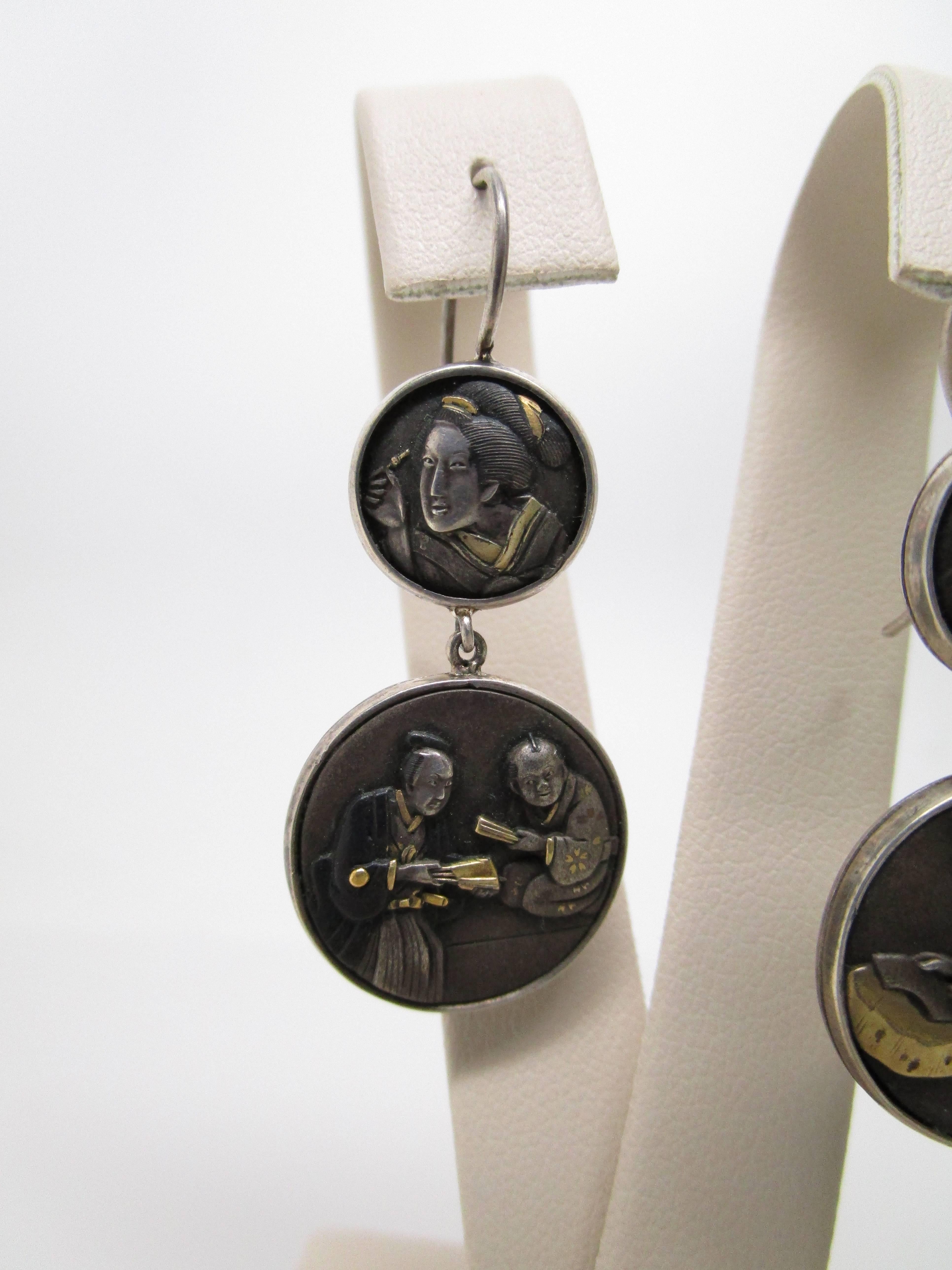 This pair of Victorian Japanese Shakudo Earrings feature two panels depicting life in Japan of old. Over one hundred years old, these panels feature beautiful scenes in the art form known as Japanese Shakudo. When Japan opened its borders in the