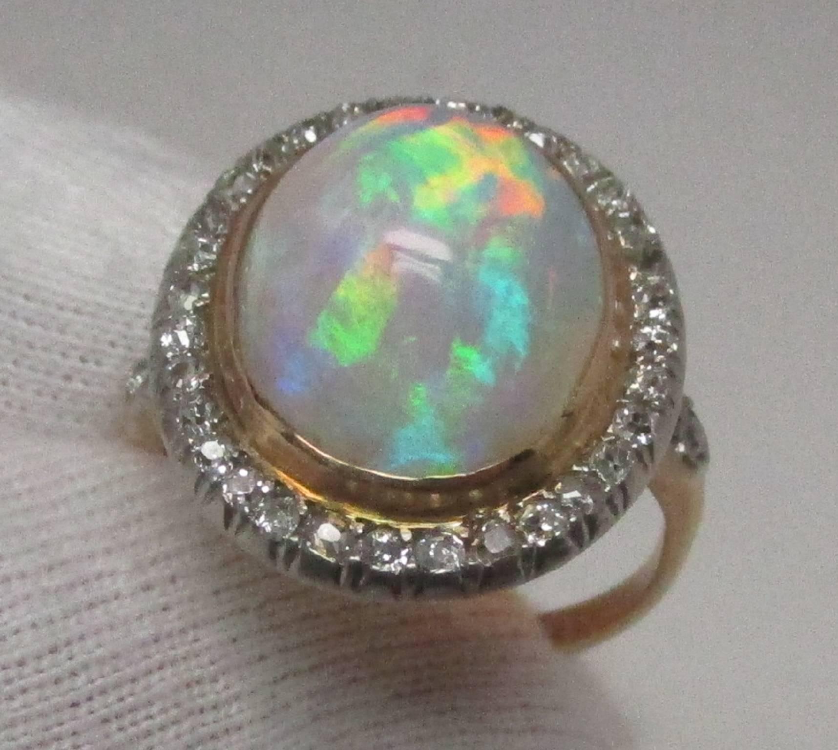 This Edwardian platinum over 18 karat gold ring features an impressive 6.06 carat opal cabochon surrounded by 32 Old Mine Cut diamonds with two more on the shoulders, equaling 1.00 carat total weight. The combination makes for a stunning presence.