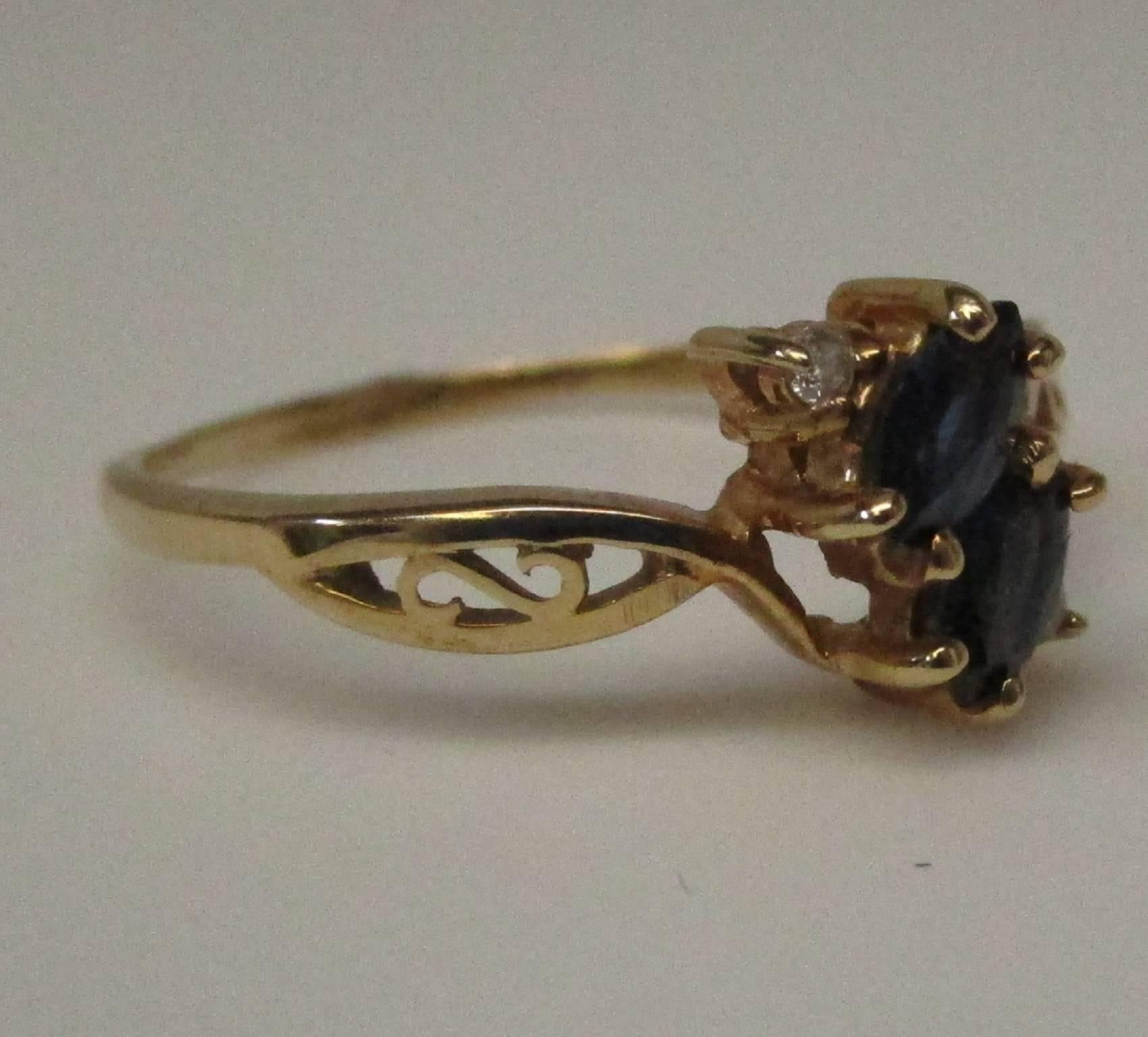 This little gem is a 14 karat yellow gold ring with two blue sapphire marquis, 0.2 carat total weight and two diamonds, 0.05 carat total weight, I color and SI1 clarity. It is a size 9, but can easily be sized to your needs. This is a comfortable