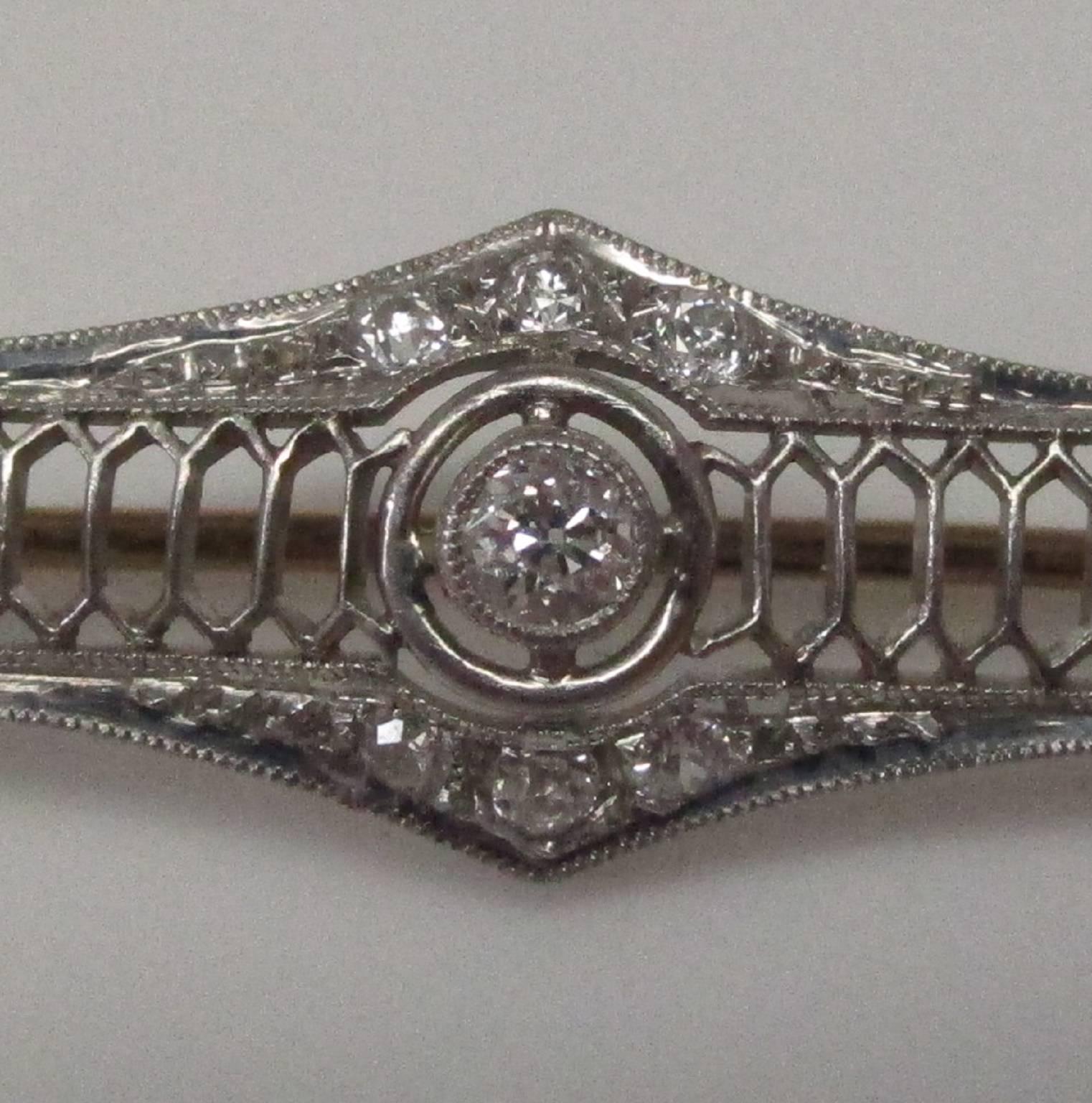 This is a beautiful example of Edwardian craftsmanship. This pin has been hand carved, not stamped. It features 19 diamonds with a total weight of 1.50 carat, G color and VS1 clarity. The pin findings are made of 14K rose gold. A work of art from a