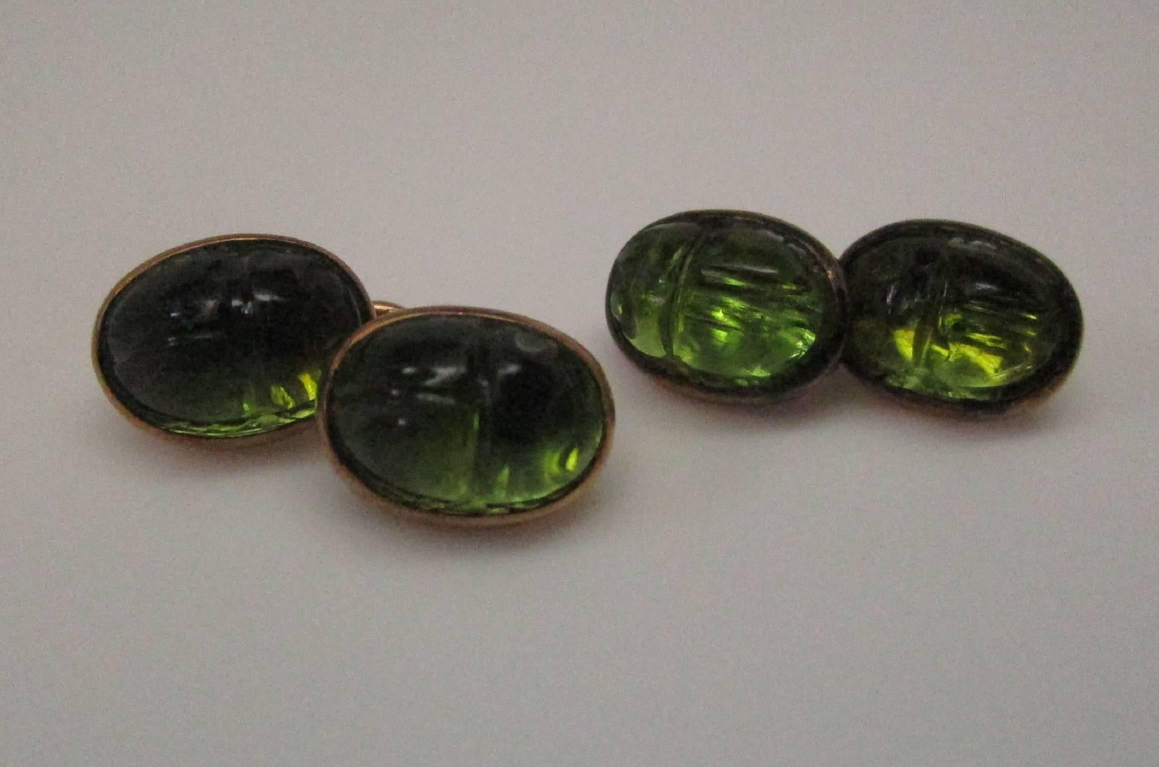 These are an exquisite pair of 15K yellow gold Victorian Egyptian Revival scarab cufflinks. The scarabs are carved from moldavite, a naturally occurring glass. Because they are backed by the gold, the scarabs appear to glow! They are in excellent
