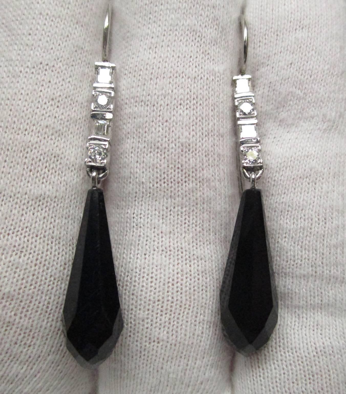 This is a truly stunning pair of Art Deco platinum earrings graced by round and square cut diamonds and a perfectly black onyx briolette. You will not see another pair of earrings like these. Dressed up or dressed down you will not fail to