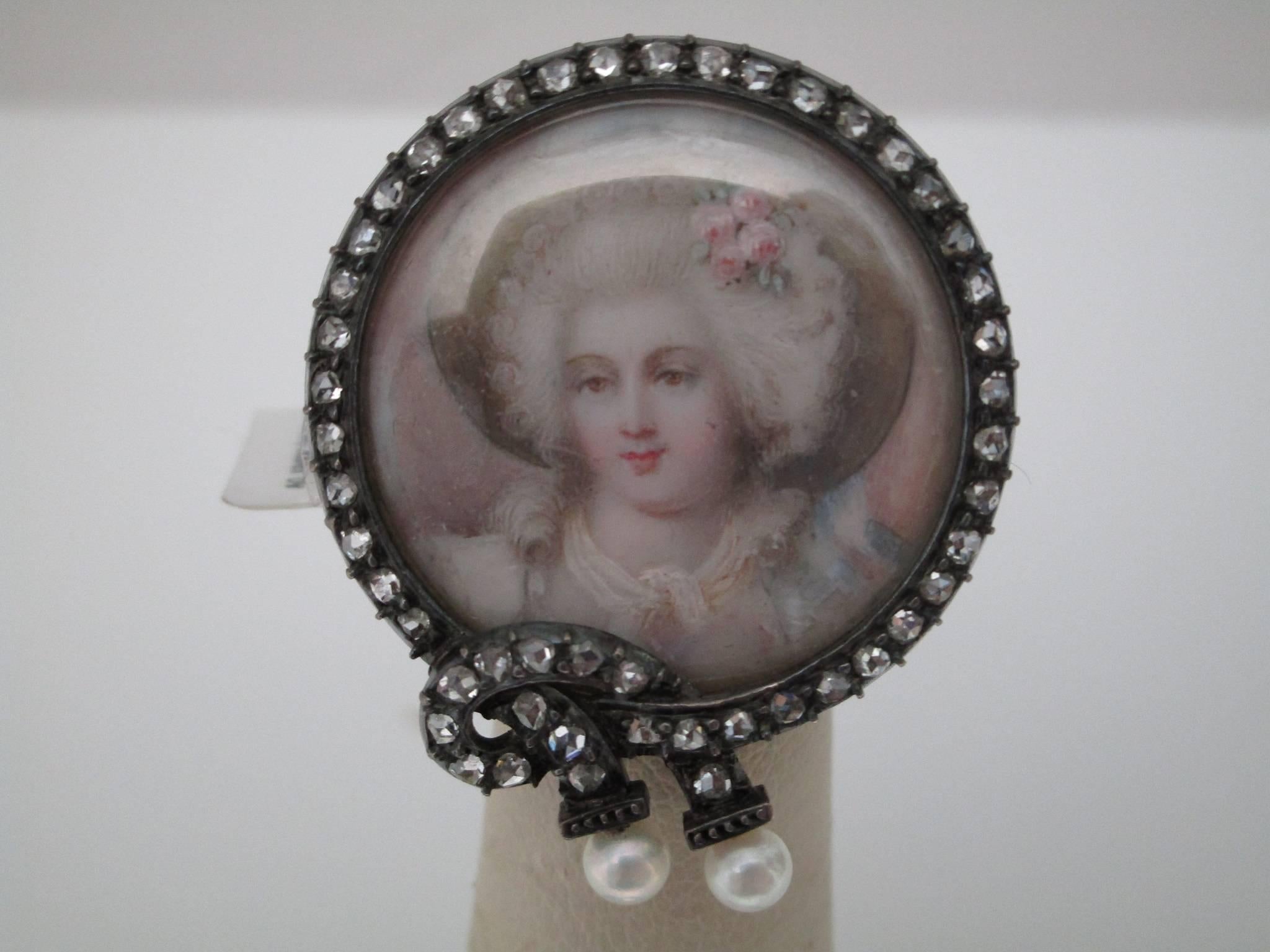  Silver over gold painted portrait pin
This charming Victorian pin features a silver over gold painted portrait of a beautiful woman. One can not help but to wonder what she is thinking. There are three initials on the back reading- J.C.S.

St. John