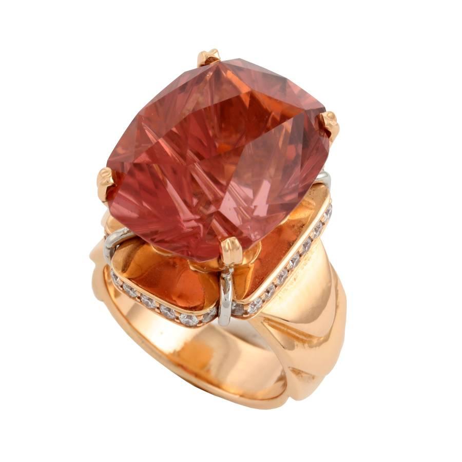 One oval fancy cut Salmon Tourmaline weighing 20.38cts., measuring 19 x 15 x 12.43mm.
32 round cut diamonds weighing .55cts, of VVS clarity.

This piece was made in Manhattan entirely by hand, and was cast, one at a time, using the lost wax process.