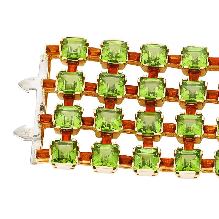 Peridot and citrine bracelet mounted in 18K. yellow gold.
64 square cut peridots weighing 170.24cts. measuring 7x7mm.
112 Baguettes cut madeira citrines, specially cut, total weight: 17.46cts.
Dimensions: 4.2 cm. wide.
Comes in a unique custom made