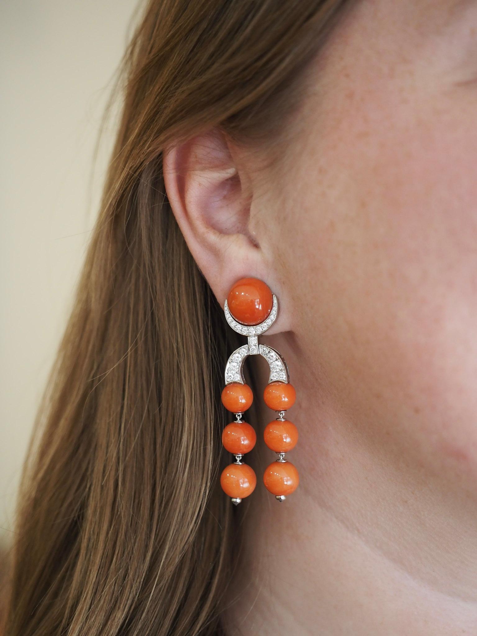Remarquables et sophistiquées, ces élégantes boucles d'oreilles en platine combinent la beauté naturelle du Corallium Rubrum avec l'éclat intemporel des diamants. Chaque boucle d'oreille est ornée d'un arrangement en cascade de 7 perles de corail
