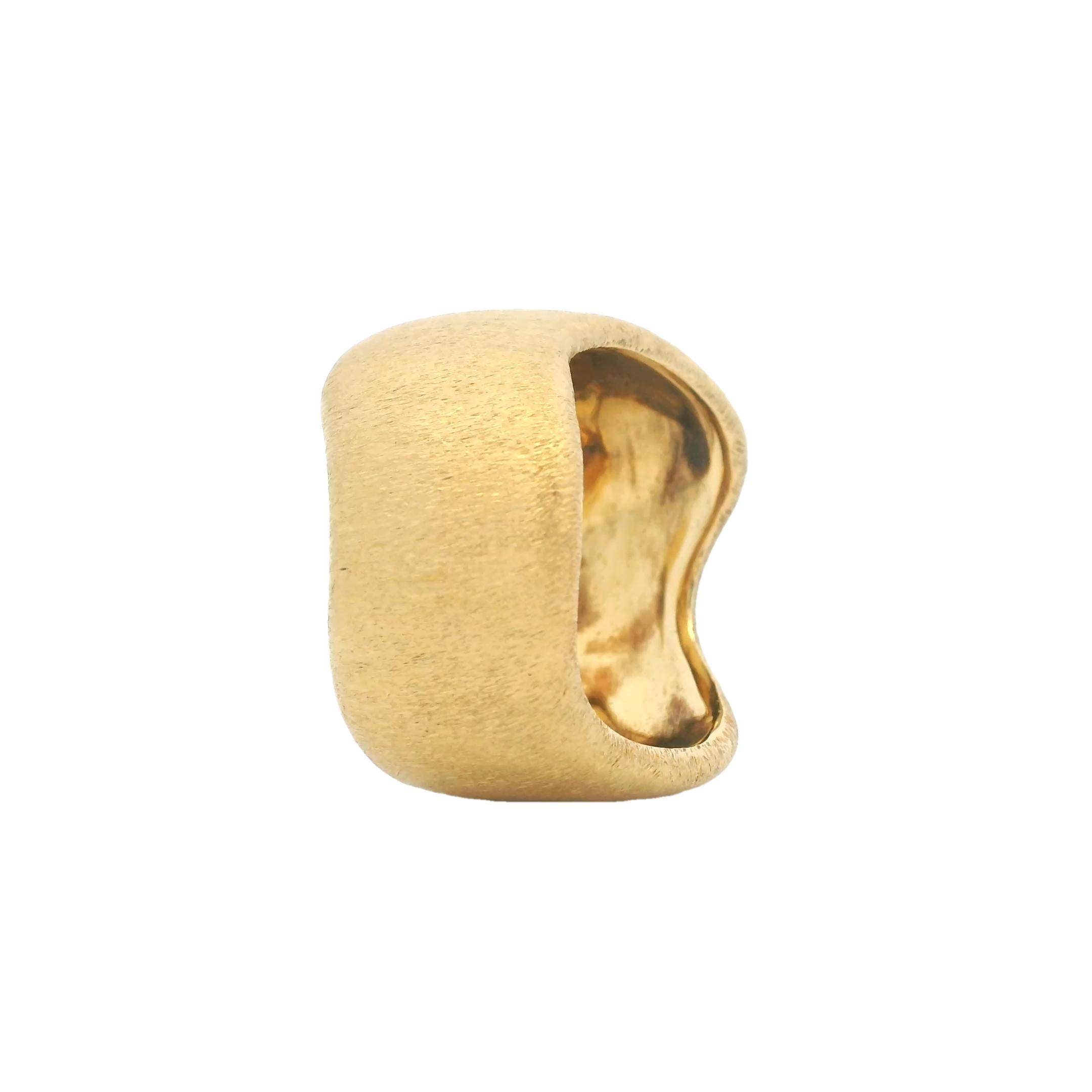Questo anello contemporaneo è realizzato in oro giallo 18 carati massiccio e rifinito con una morbida texture satinata e opaca. Il design è caratterizzato da una silhouette organica e ondulata con contorni fluidi che avvolgono graziosamente il dito,
