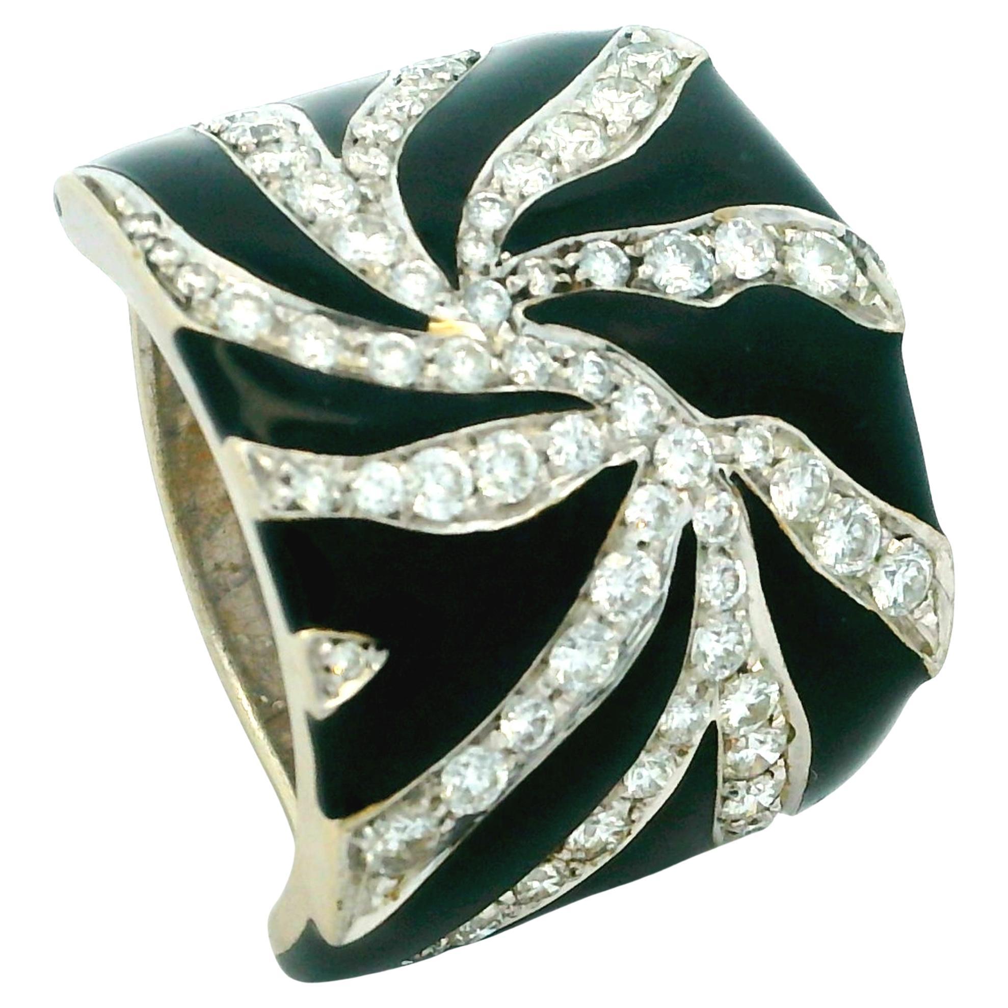 Expression dramatique du glamour des années 1980, cette audacieuse bague de cocktail est réalisée de main de maître en or blanc 18 carats et présente un motif tourbillonnant hypnotique d'émail noir brillant et de diamants éblouissants. La partie