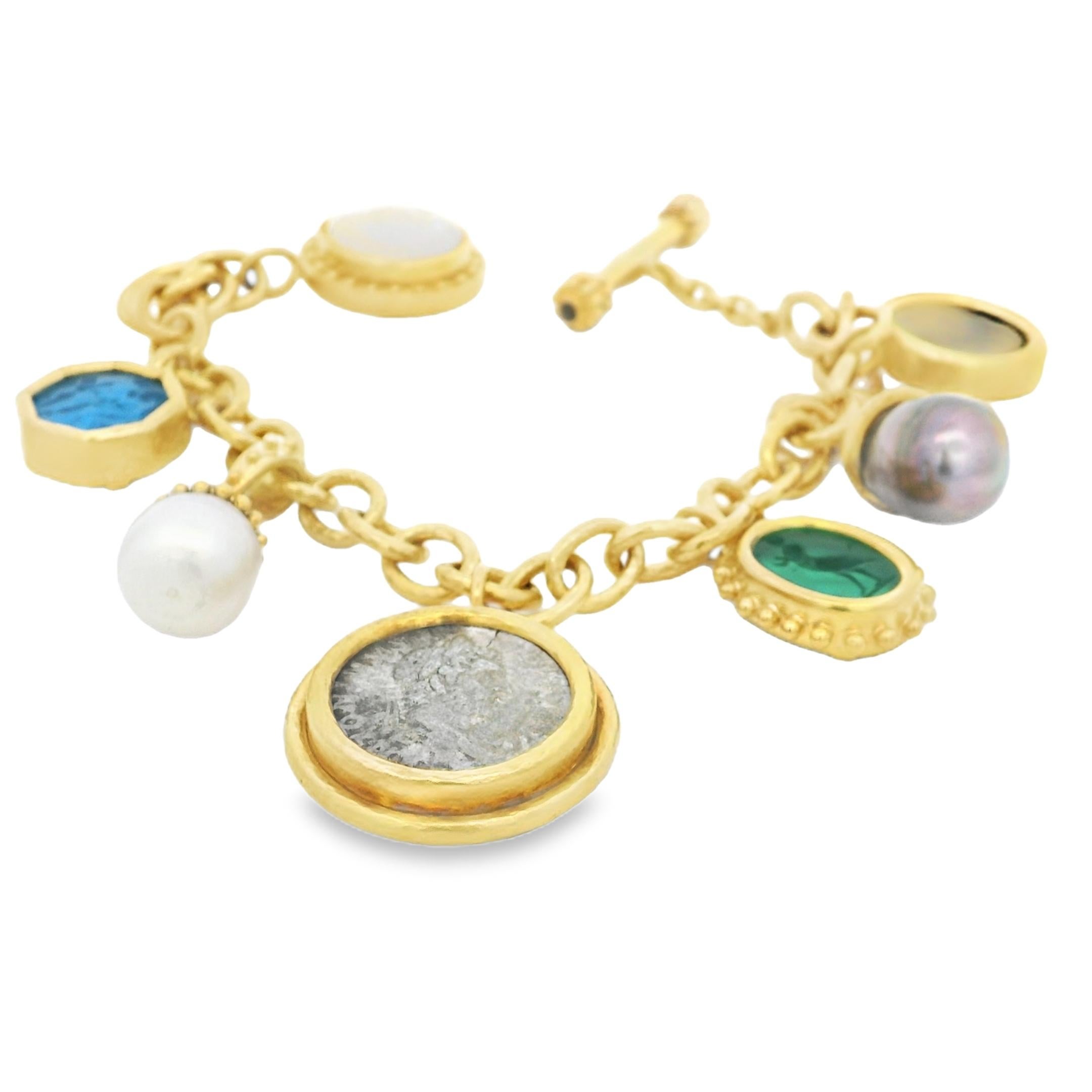 Un bracelet à breloques intemporel et de collection d'Elizabeth Locke, fabriqué à la main en riche or jaune 18 carats avec la finition martelée caractéristique de la créatrice. Cet élégant bracelet de 7,5 pouces présente un éventail de charmes