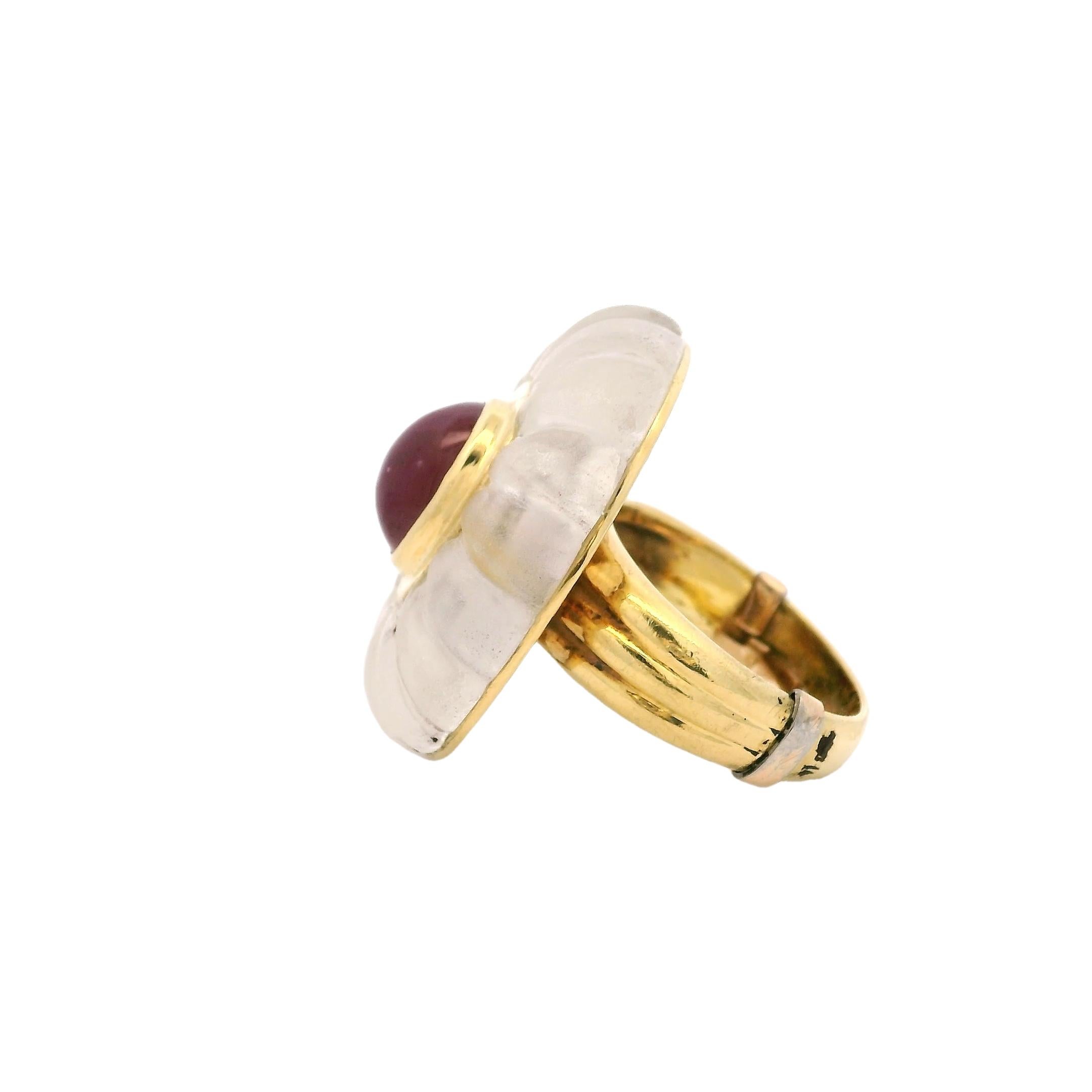 Un elegante e scultoreo anello da cocktail realizzato in Italia in oro giallo 18 carati, caratterizzato da una cupola scanalata di cristallo di rocca finemente intagliata. Al centro, un rubino cabochon da 2,00 carati, riccamente colorato, è