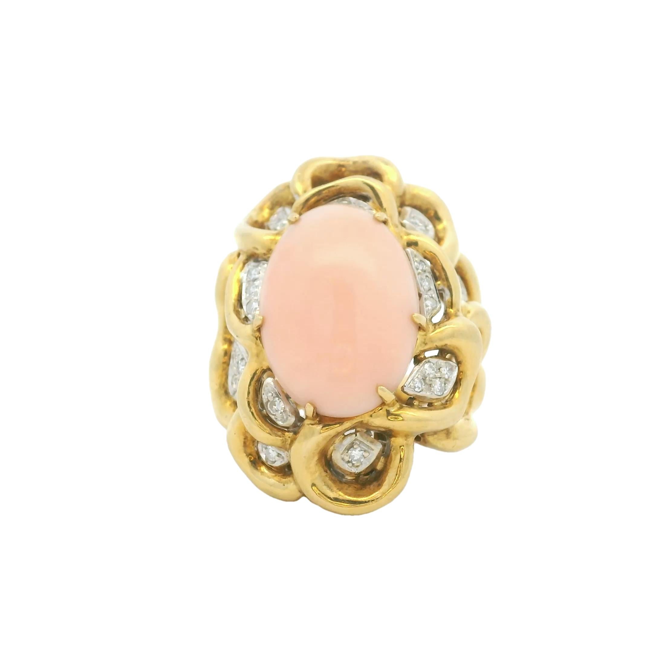 Un anello vintage splendidamente composto che mostra un cabochon di corallo pelle d'angelo lucidato incastonato in una montatura fluida e scultorea in oro giallo 18 carati. Il design organico traforato evoca la morbidezza della natura ed è