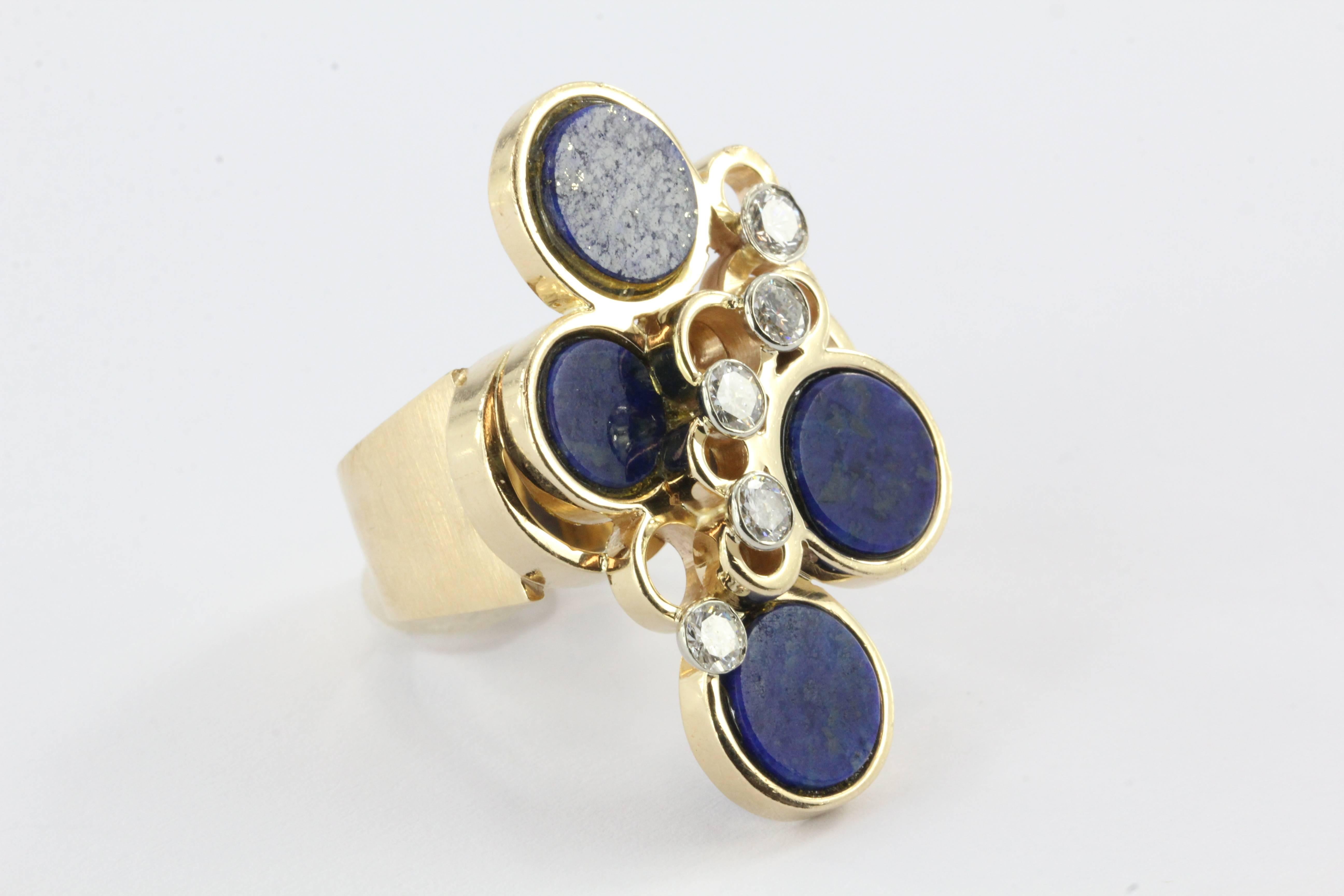 This fantastic mid century lapis and diamond cocktail ring is high on style and low on profile -  making it extremely wearable and an option for everyday use. 

The 14k yellow gold ring is embellished with four discs of lapis (each measuring 8.6mm