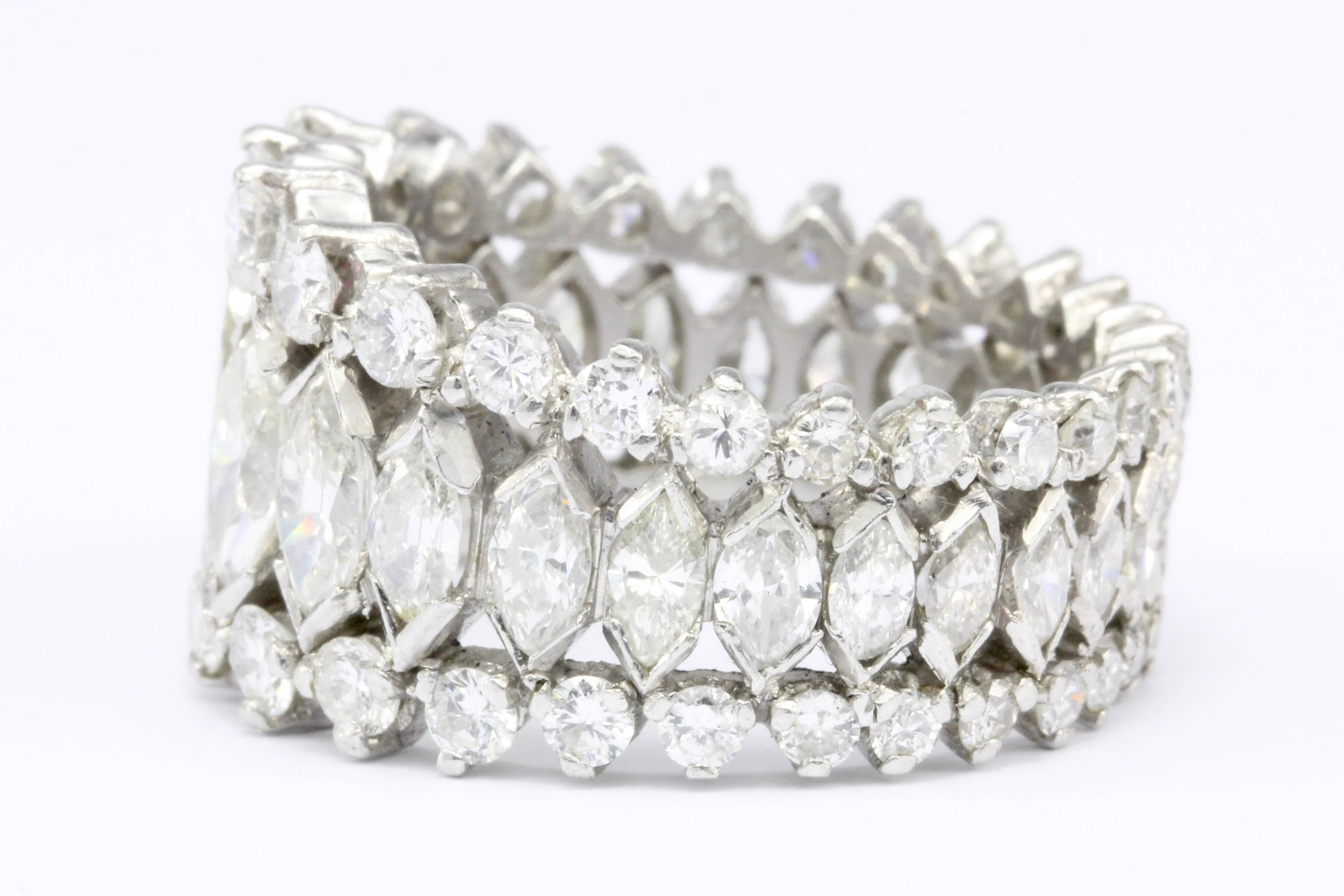 Era: Retro c. 1950s

Composition: Platinum 

Primary Stone: Marquise Cut Diamond

Stone Carat: 3 CTW

Color: J/K

Clarity: VS1/2

Accent Stone: Round Brilliant Cut Diamonds 

Color: H-J

Clarity: Vs1-Si1

Total Accent Diamond Weight: 2 CTW

Total