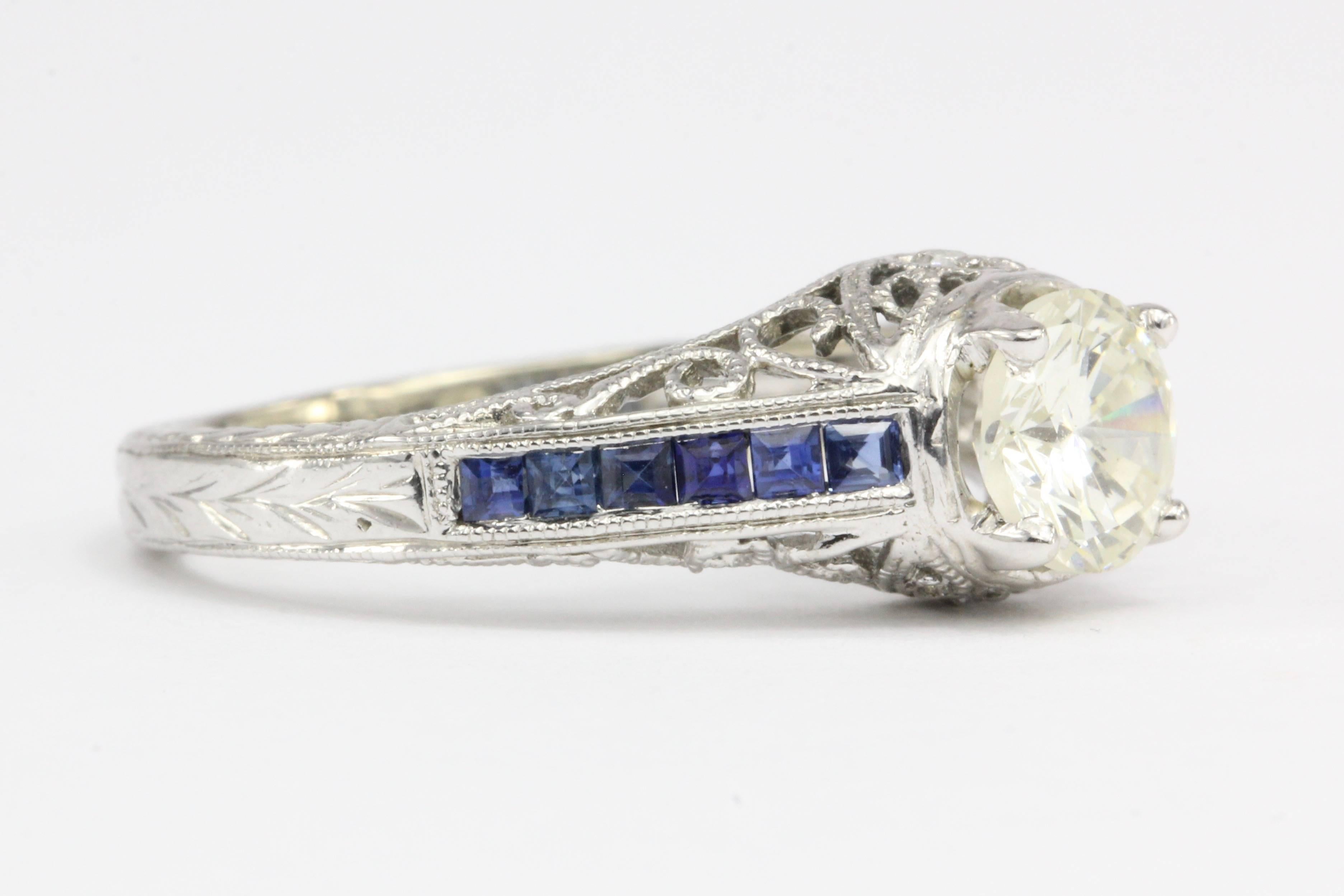 Era: Art Deco Style Modern 

Composition: 14K white gold

Primary Stone: Diamond

Stone Carat: 1 CT

Color: K/L

Clarity: Si2/I1

Secondary Stone: Natural Sapphire

Color: Blue

Carat Weight: .50 CTW

Ring Face: 5.7mm x 6.2mm wide

Ring Size: