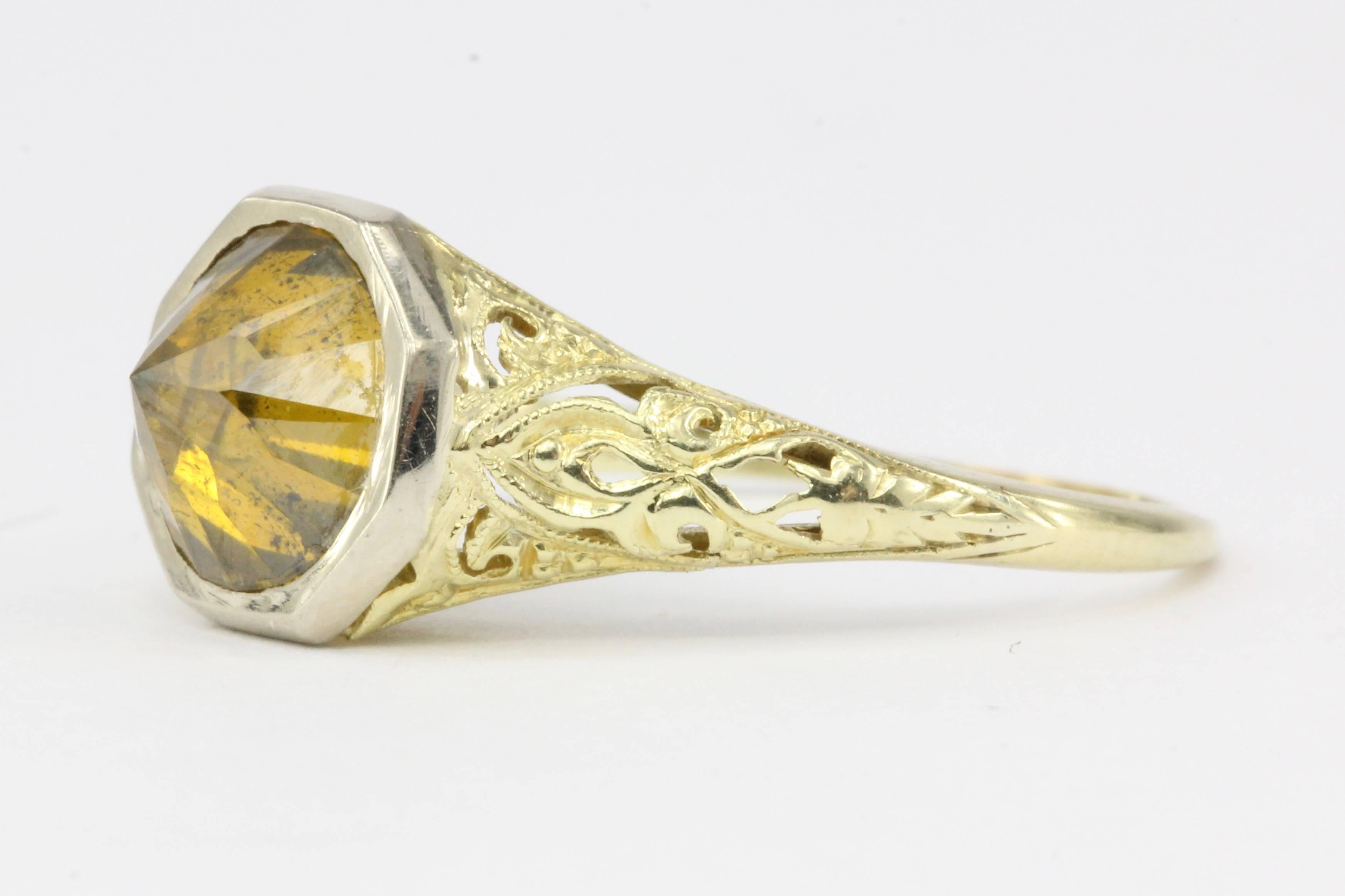 Era: Art Deco Setting, Modern Cut Stone

Composition: 14K Yellow Gold & Platinum 

Primary Stone: Diamond

Stone Carat: 2 Carat

Color: Fancy Yellow/Orange

Clarity: I2

Ring Face: 9.75mm x 9.4mm wide

Ring Size: 8

Ring Weight: 2.3 grams

Ring