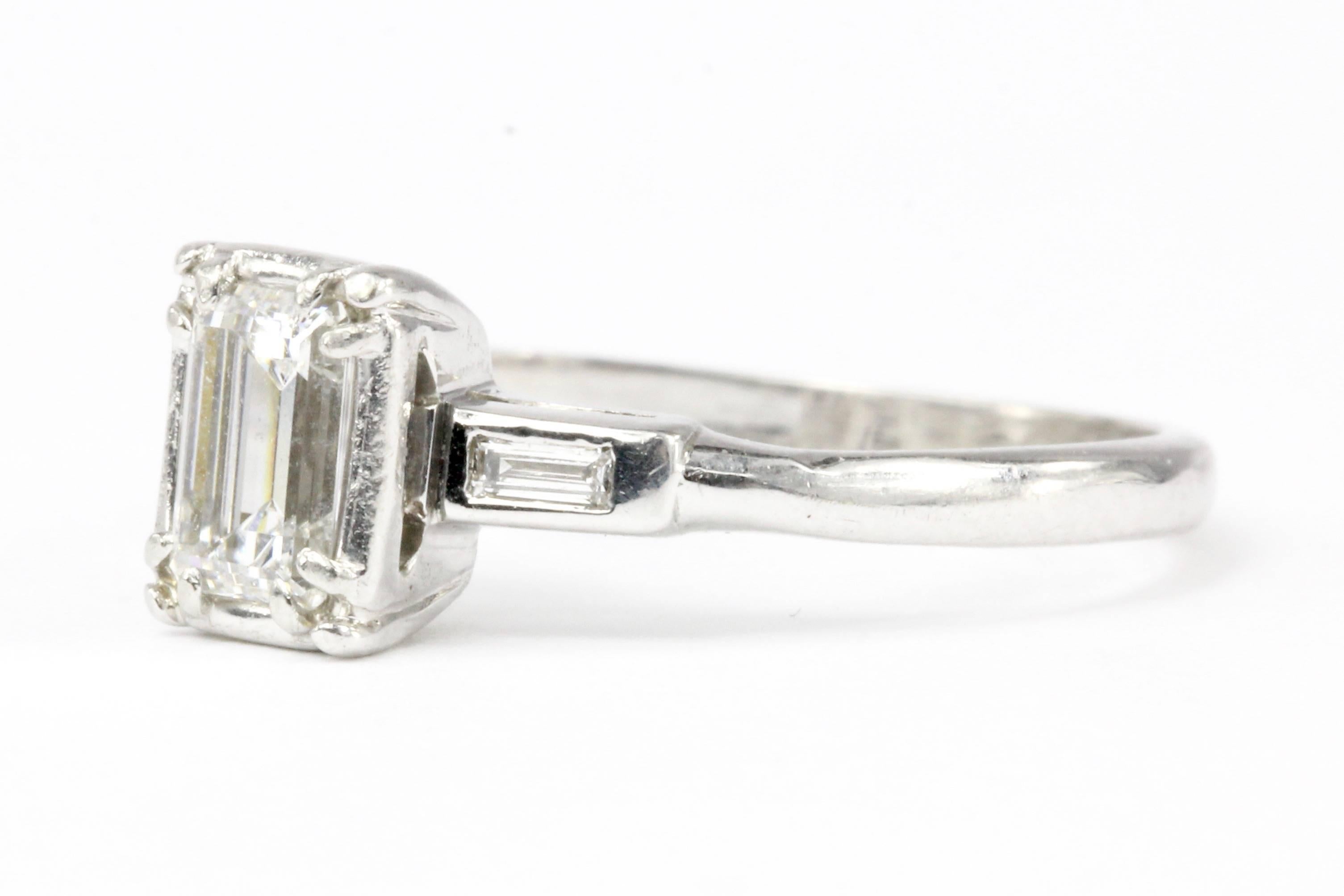 Era: Art Deco c. 1940s

Composition: 14k White Gold

Primary Stone: Diamond

Stone Carat: .52 Carat

Color: F

Clarity: VS1

Cut: Emerald

Accent Stone: Diamond

Color:F

Clarity: VS1

Cut: Baguette

Total Accent Stone Weight: .10CTW

Ring Face