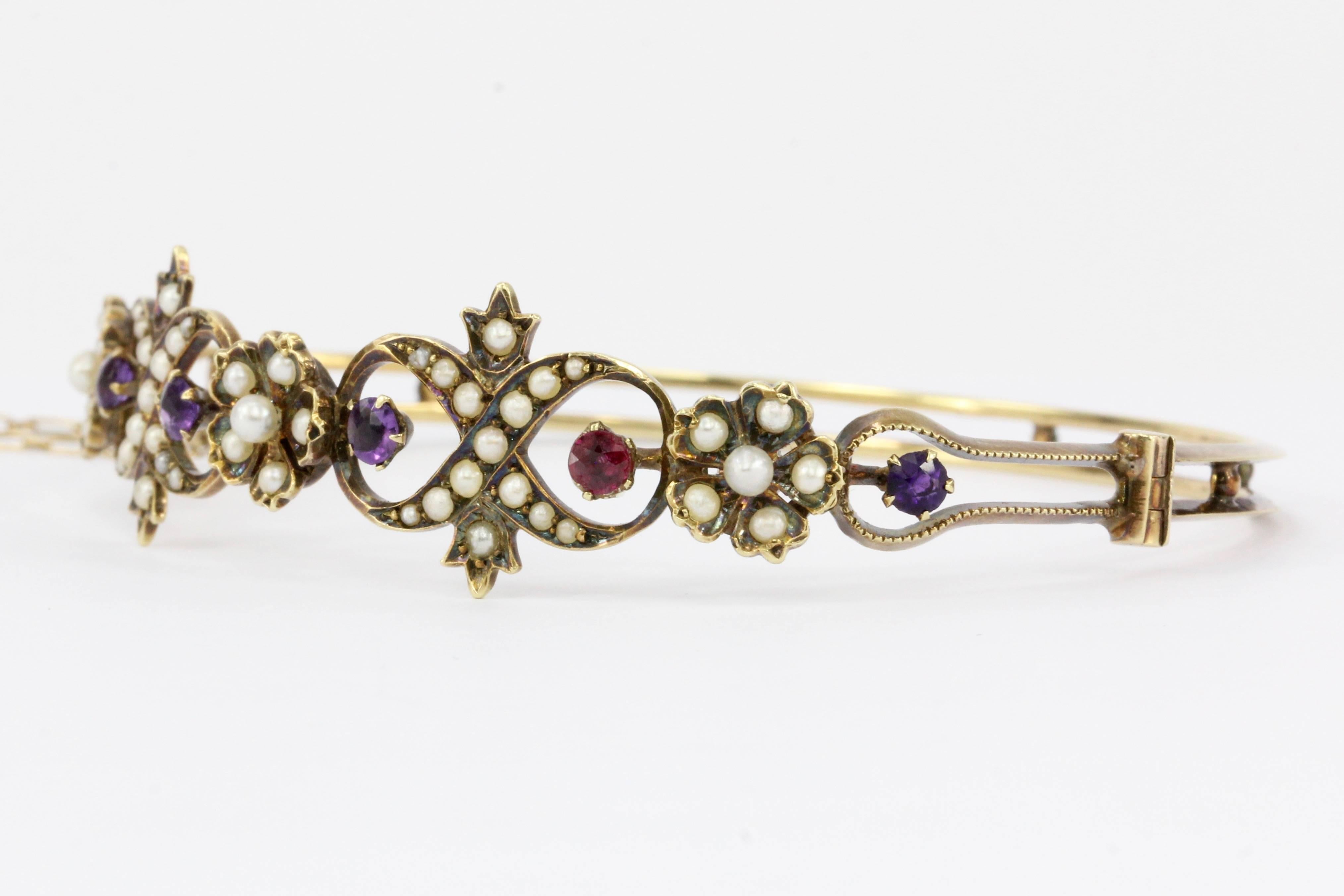Era: Late Victorian c.1895

Hallmark: 14K 

Makers Mark: Wishbone - L.V. Roy & Co. 1897-1922 Providence, R.I.

Composition: 14K Yellow Gold

Primary Stone: Amethyst 

Secondary Stone: Ruby

Tertiary Stone: Seed Pearl

Bracelet Bangle dimensions: