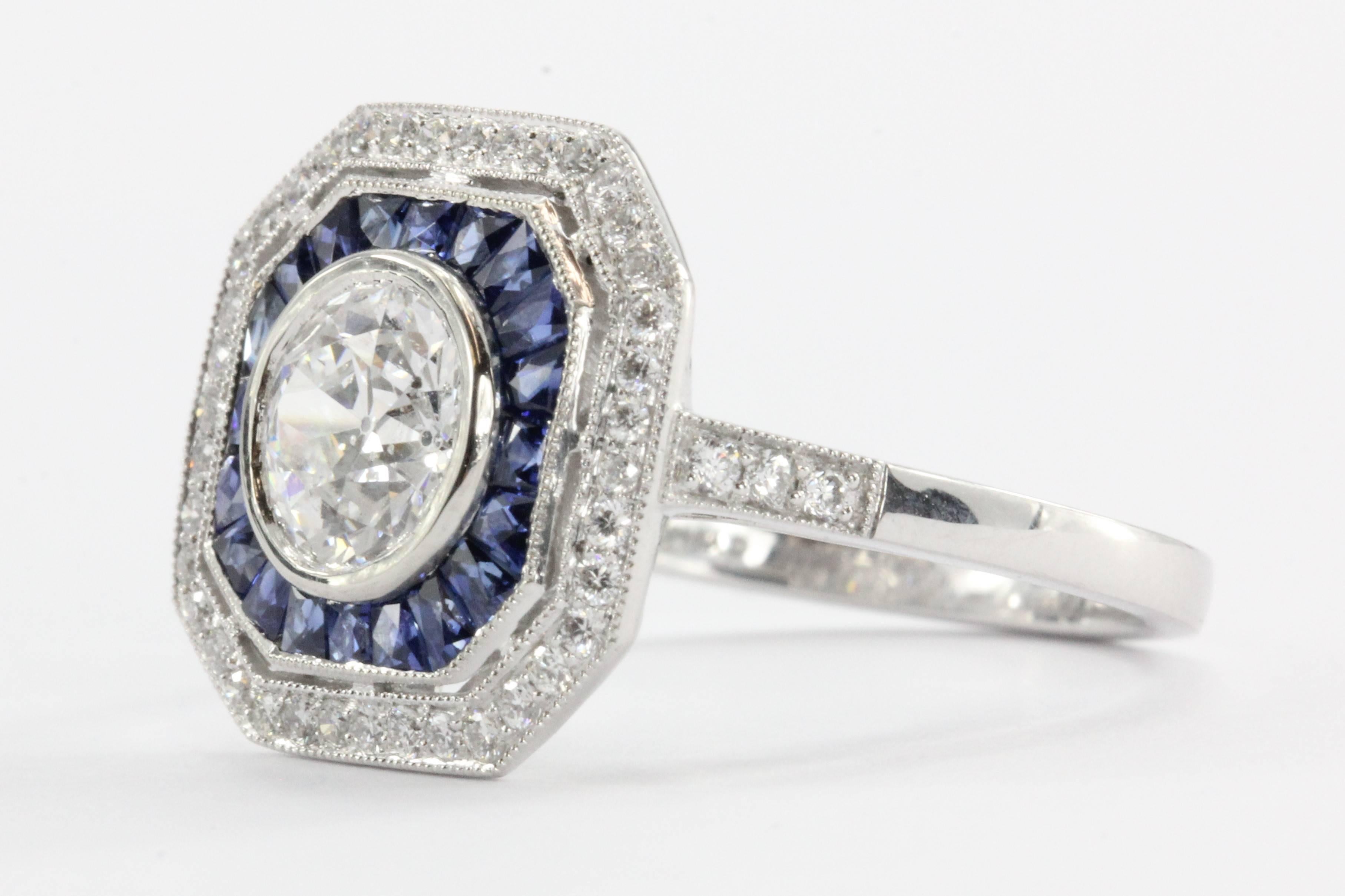 Brand New Sophia D Art Deco inspired platinum set diamond and sapphire engagement ring. The center stone is a genuine antique diamond.  The diamond is an old European cut 1.02 carat, E color, I1 clarity. The center stone is GIA certified and come