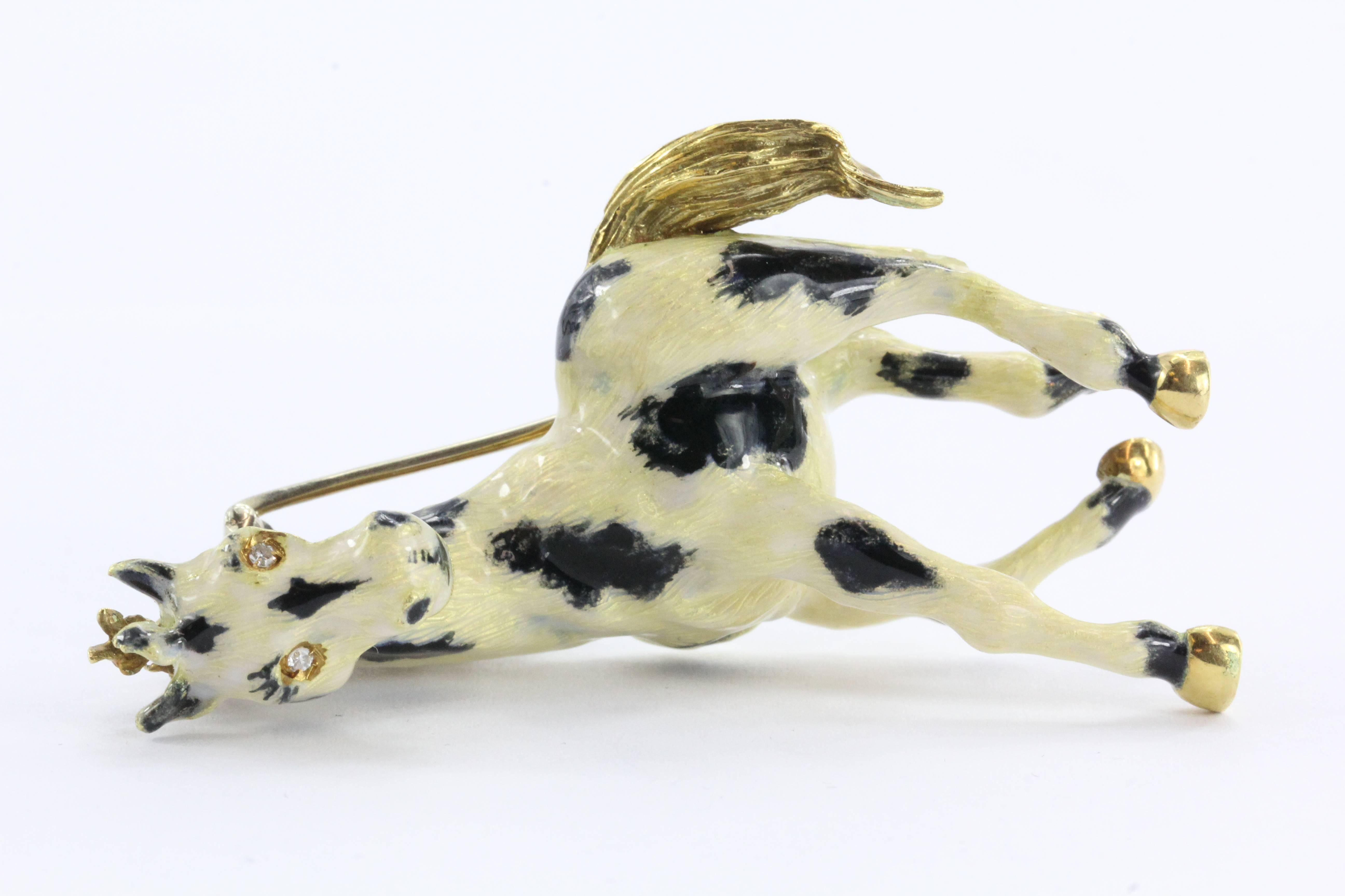 
This amazingly unique gold, diamond, and enamel paint horse brooch pin is a true work of art. The brooch features a gorgeous black and golden yellow horse crafted entirely of 18k yellow gold which has been ornamented with round single cut diamonds